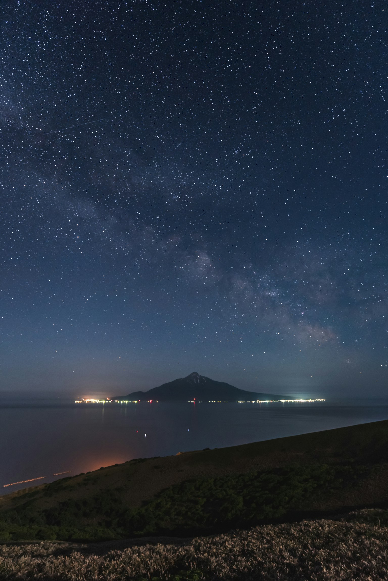 星空與海洋環繞的山的夜景