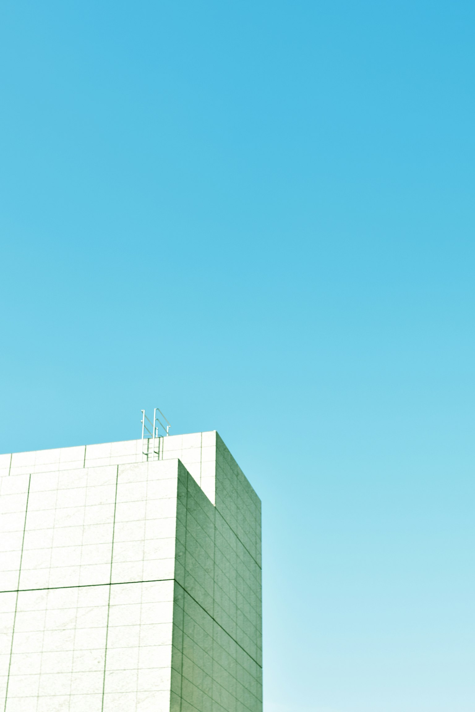 Parte di un edificio moderno sotto un cielo blu chiaro con colori vivaci e design semplice