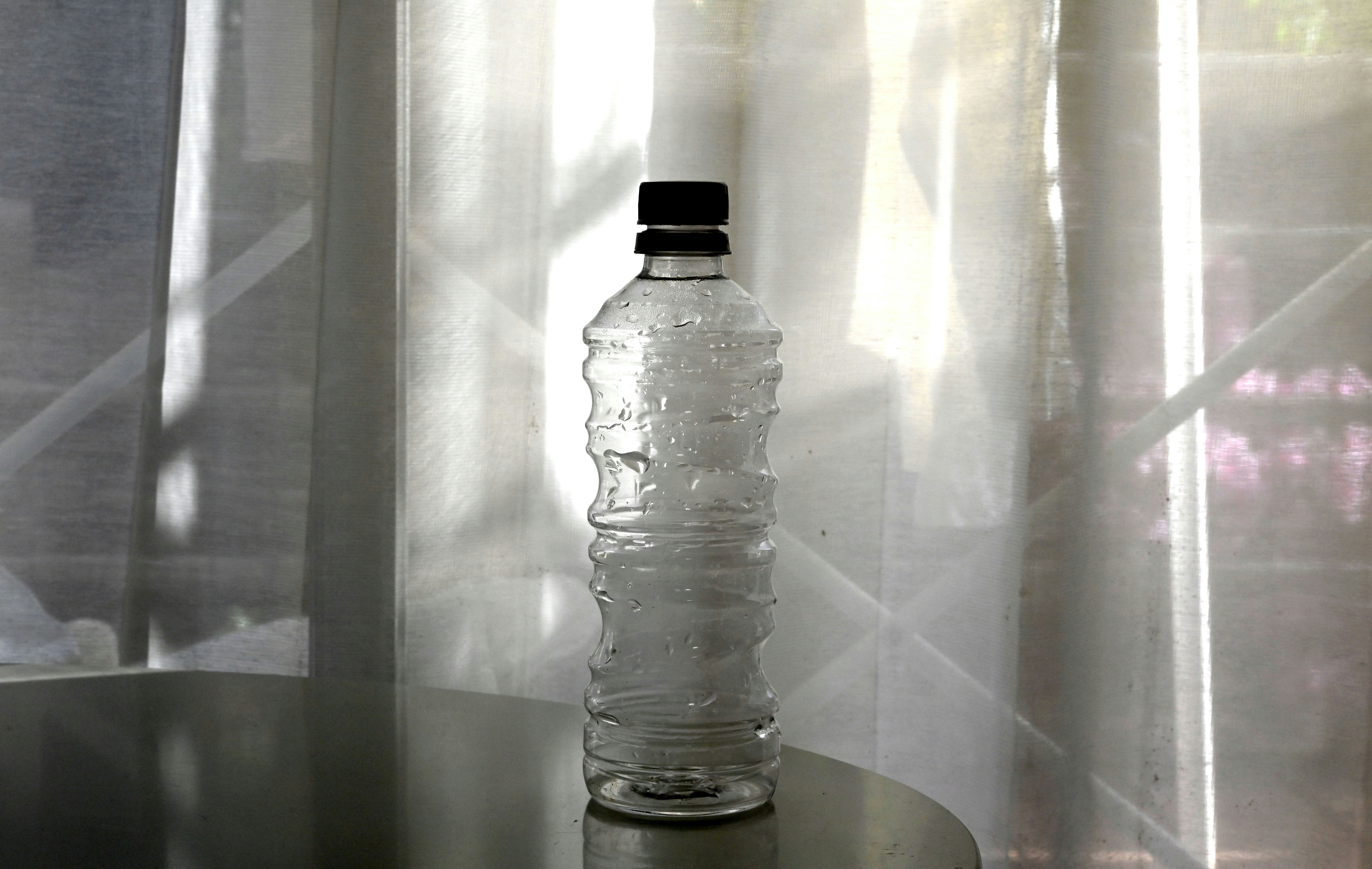 阳光照射的室内塑料水瓶特写