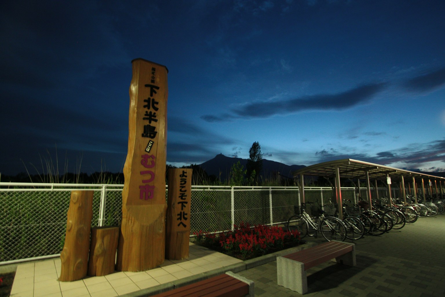 夜空下的大木標誌和自行車停放區