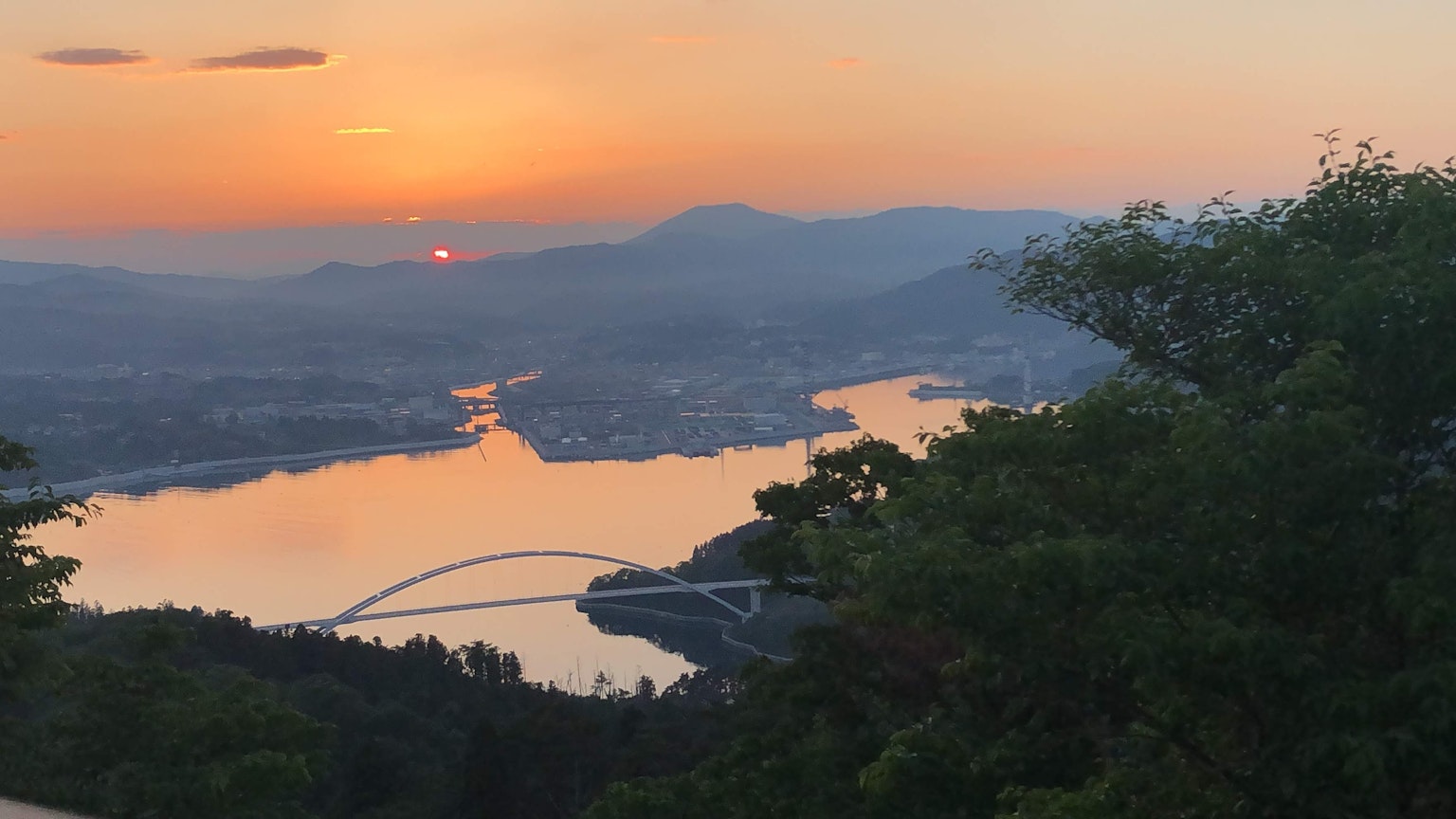 Scenic view of a sunset over a river with mountains