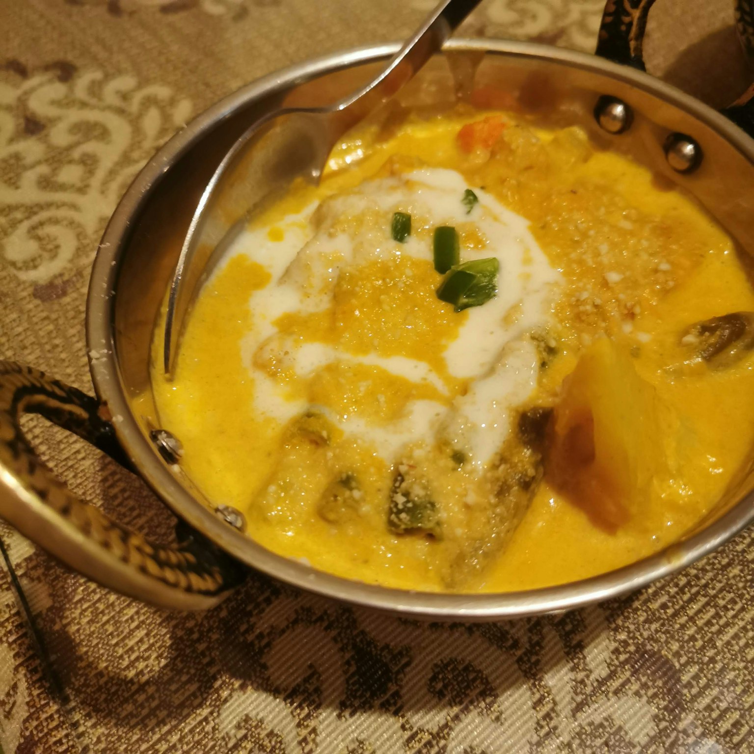 Curry cremoso con verdure in una ciotola di metallo