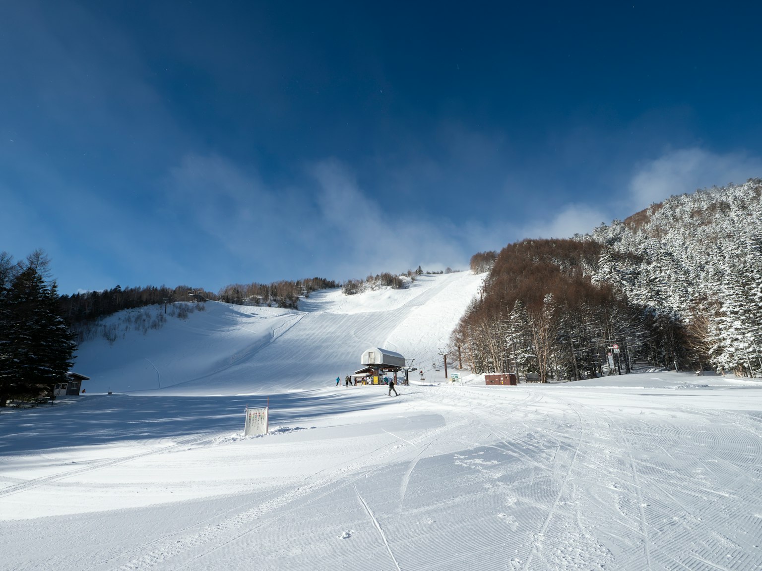 被雪覆蓋的滑雪度假村風景晴朗的藍天和可見的樹木