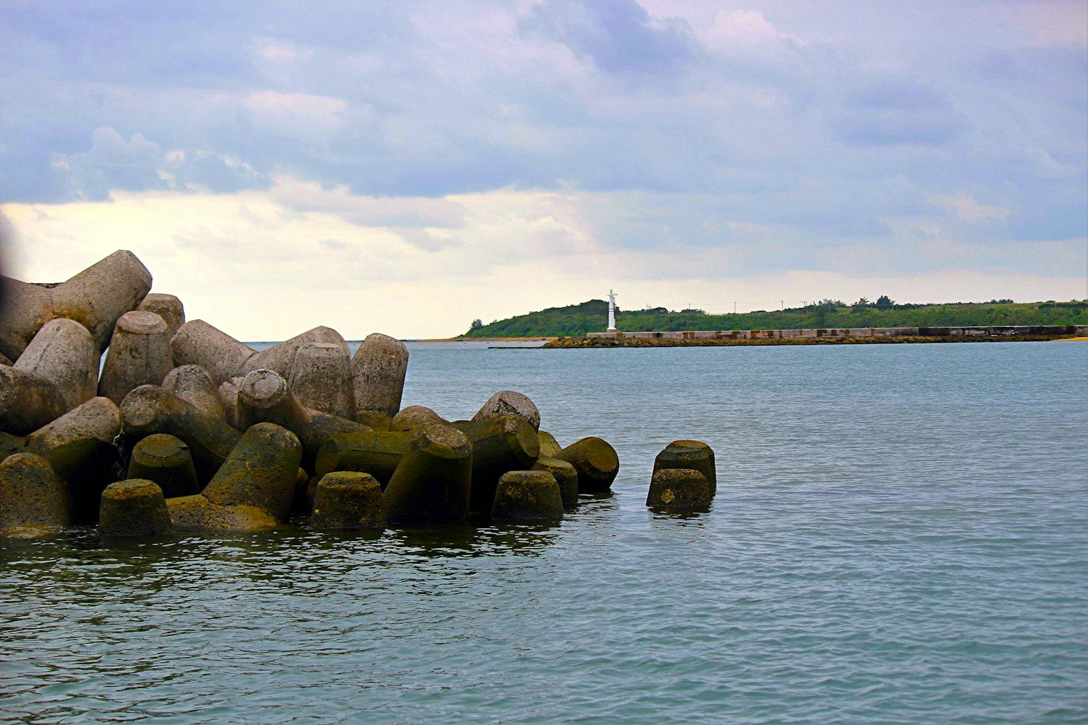 Vista di rocce costiere e faro Acqua calma che riflette le nuvole