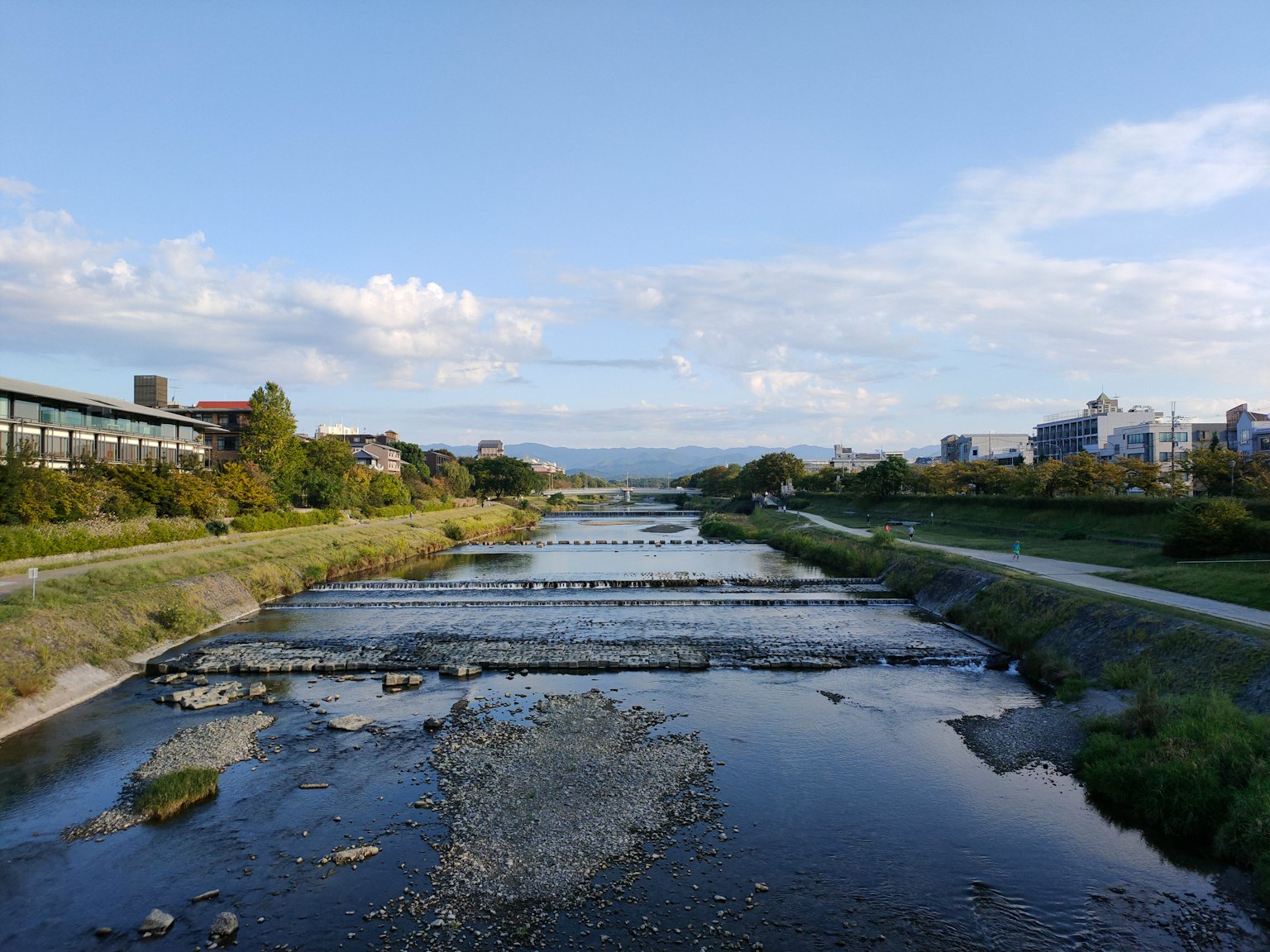 Vista panoramica di un fiume con vegetazione e edifici circostanti