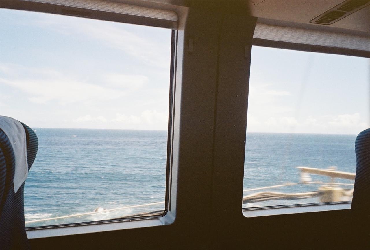 海の景色を望む列車の窓からの眺め