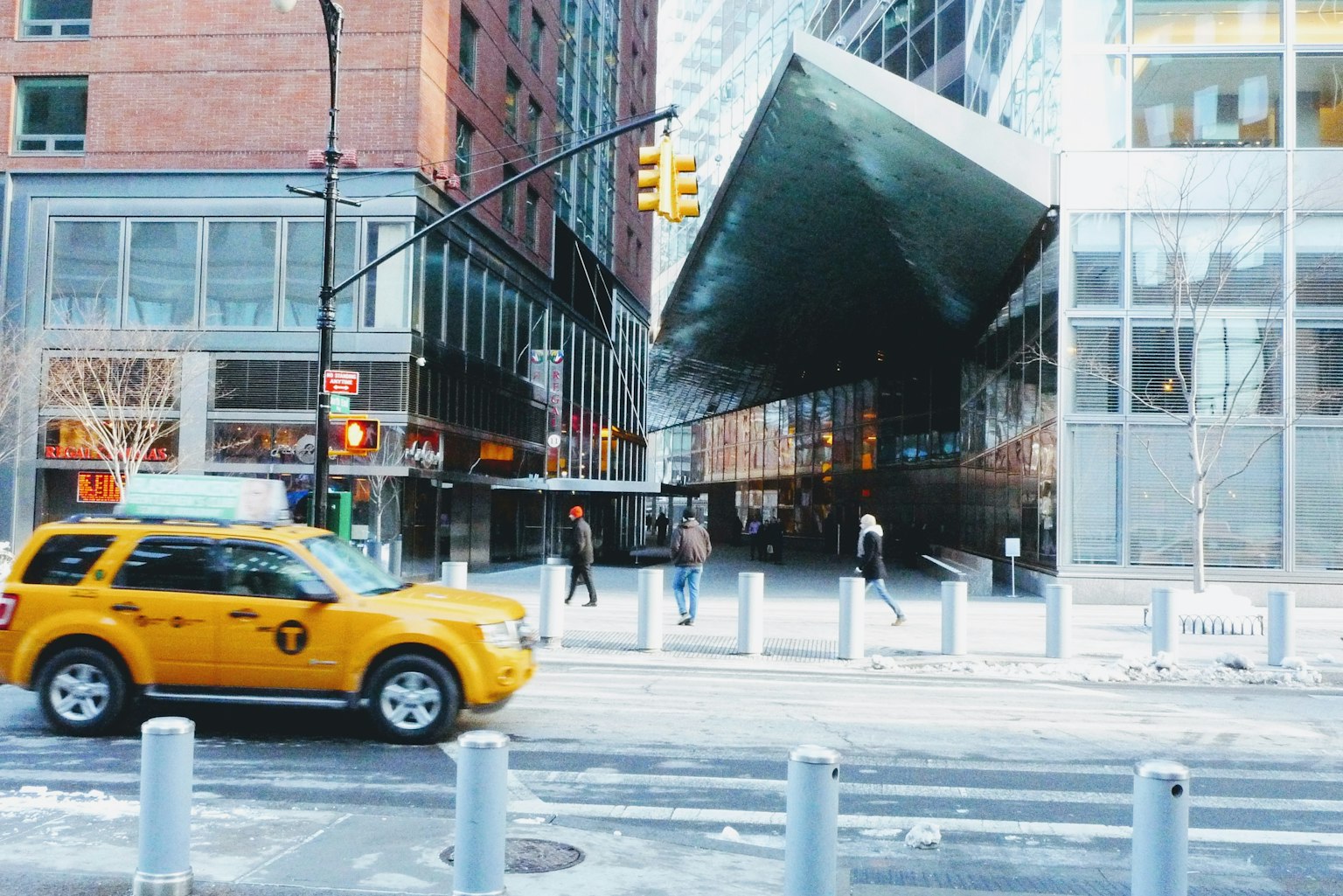 Taxi amarillo en una esquina de Manhattan con un edificio moderno