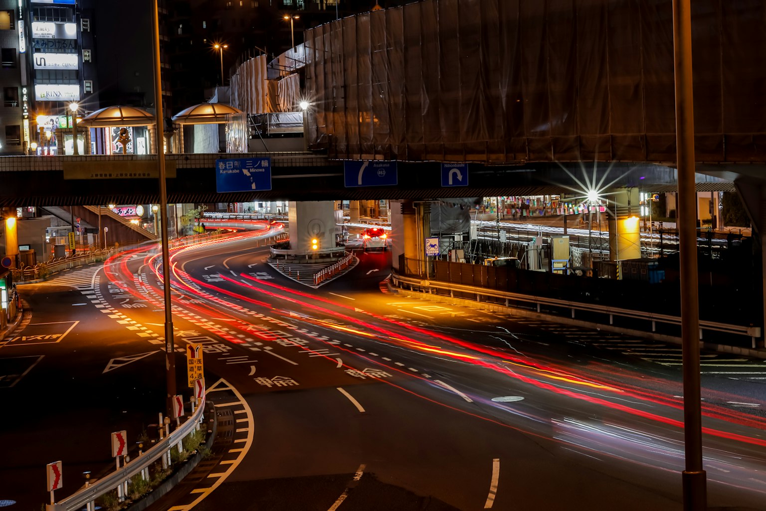 Incrocio urbano notturno con luci di auto in movimento