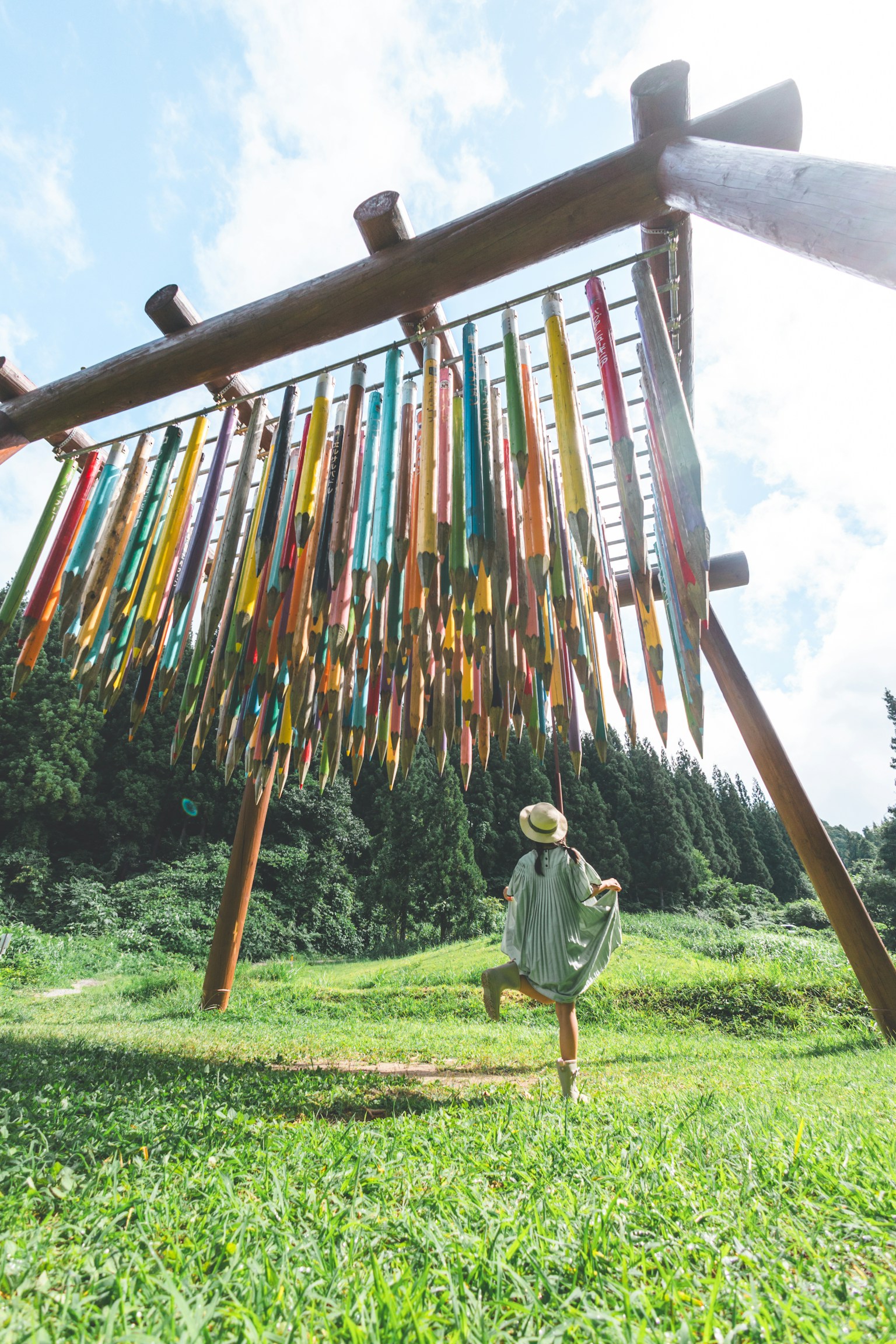 一個人站在一個大型結構下，五顏六色的漆棒懸掛著