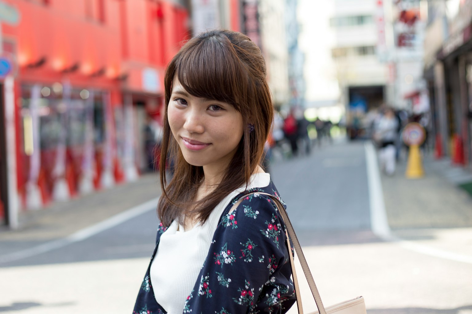 Portrait of a woman smiling in front of red buildings
