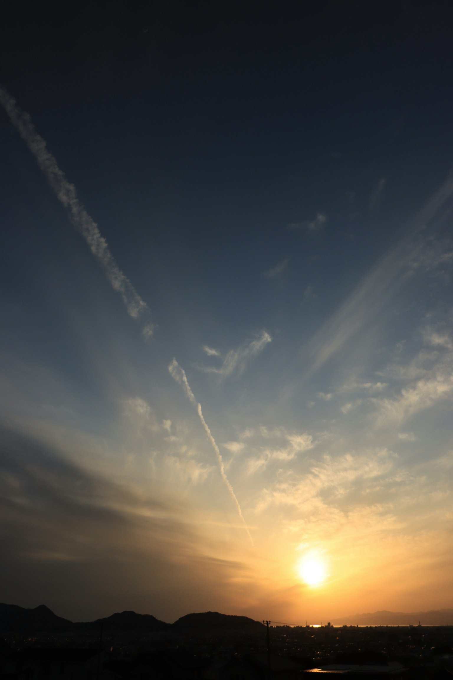 Bellissimo cielo al tramonto con nuvole varie e scie di aerei