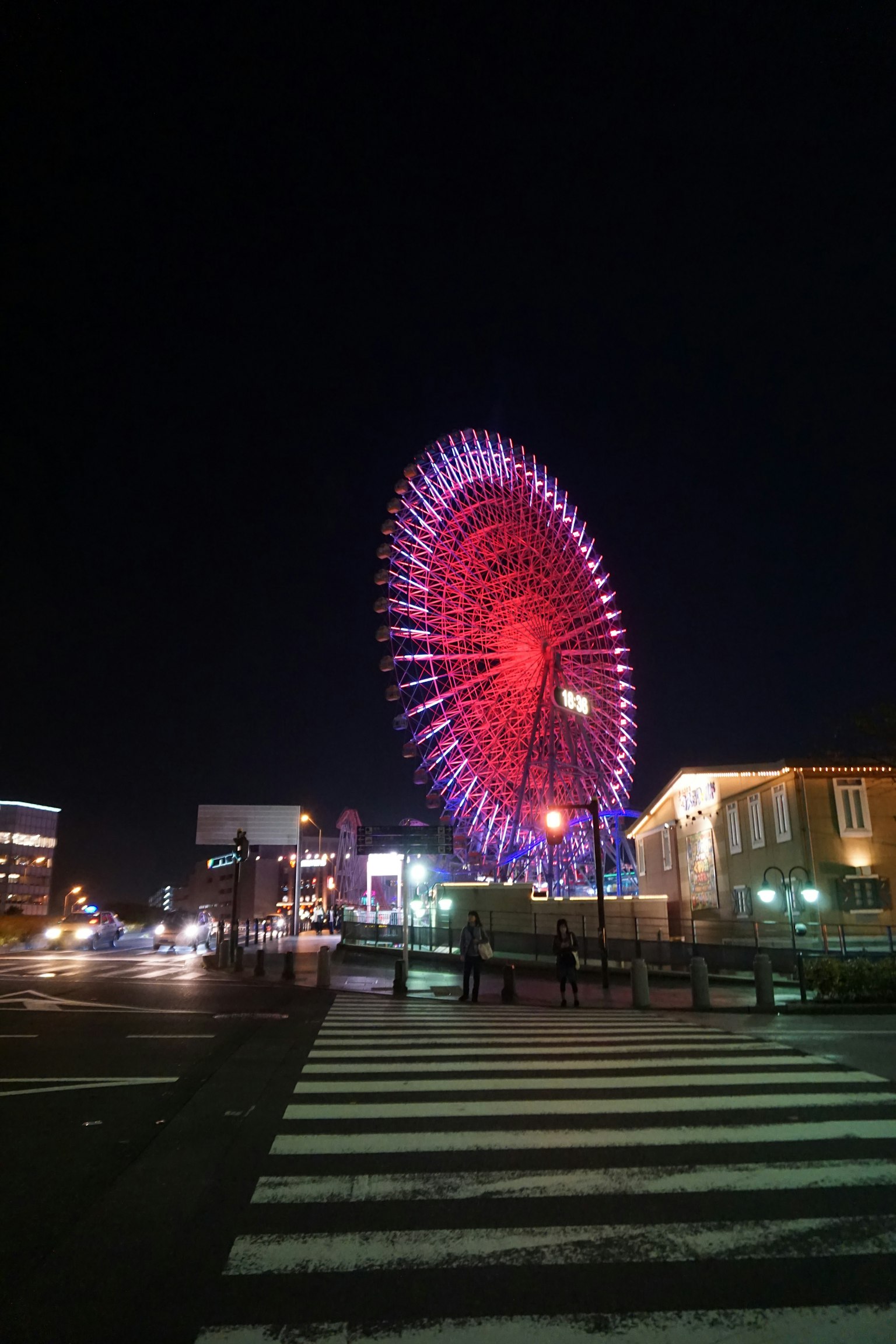 Ein leuchtendes rotes Riesenrad bei Nacht