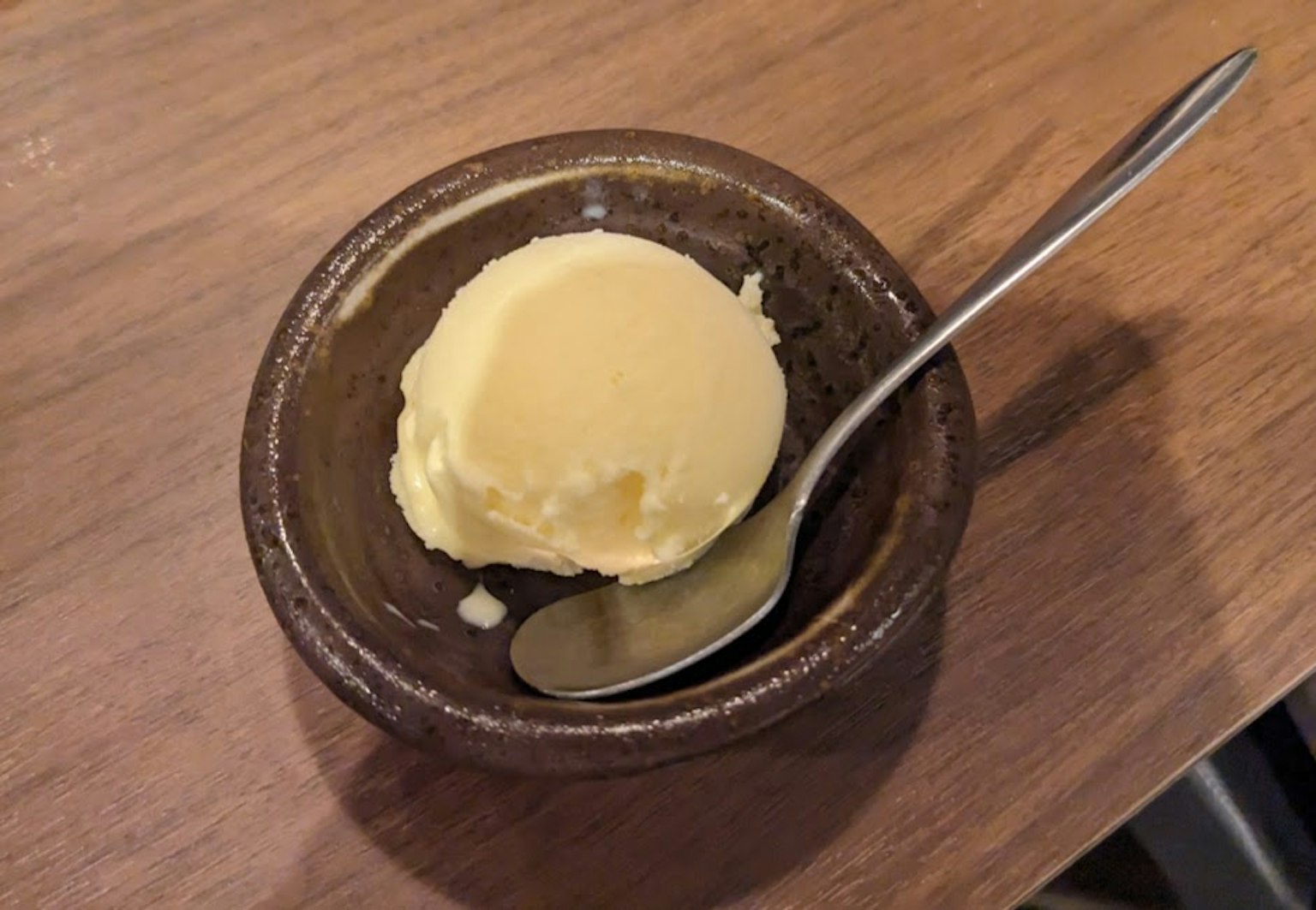棕色陶瓷碗中的奶油黃油和銀色湯匙
