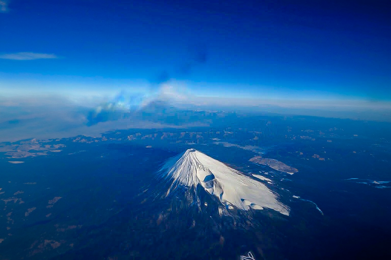 Puncak gunung berapi bersalju di bawah langit biru jernih