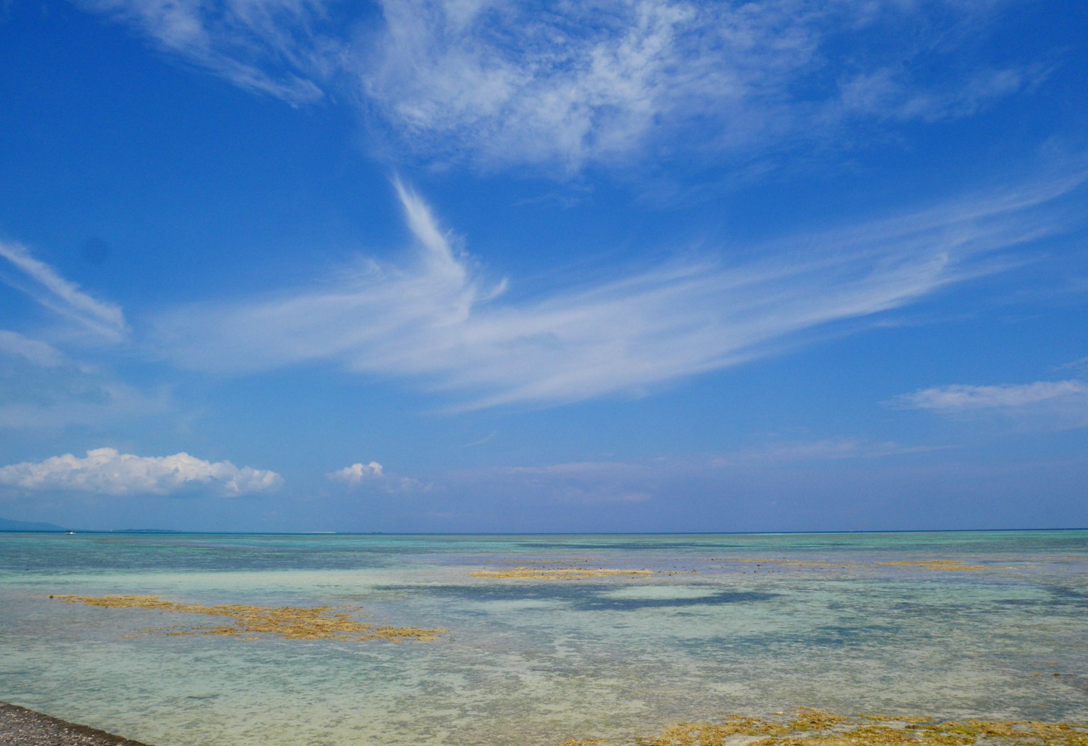 Vista panoramica di cielo blu e oceano cristallino con onde leggere e modelli nuvolosi