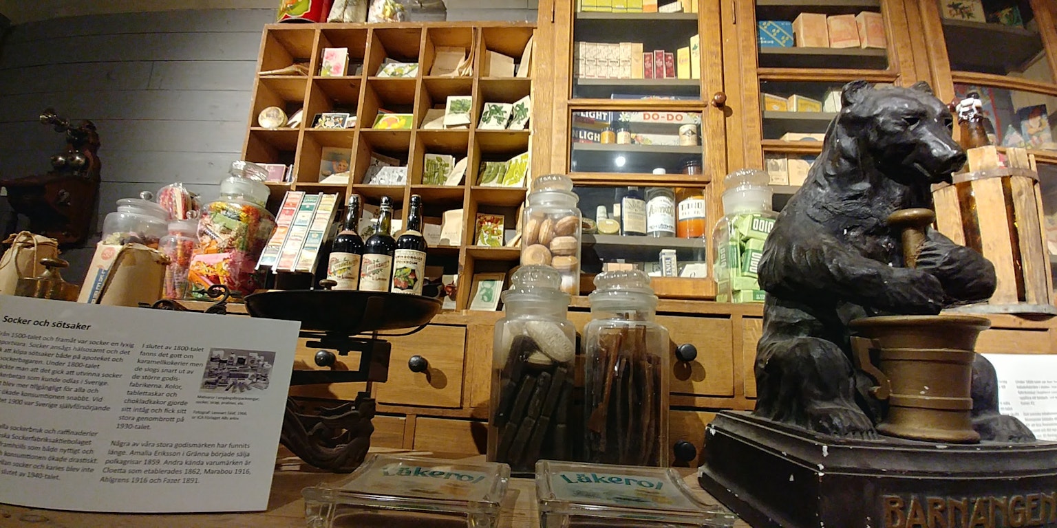 古风商店内部，木架上的罐子和包装商品，以及一座雕刻的熊雕像
