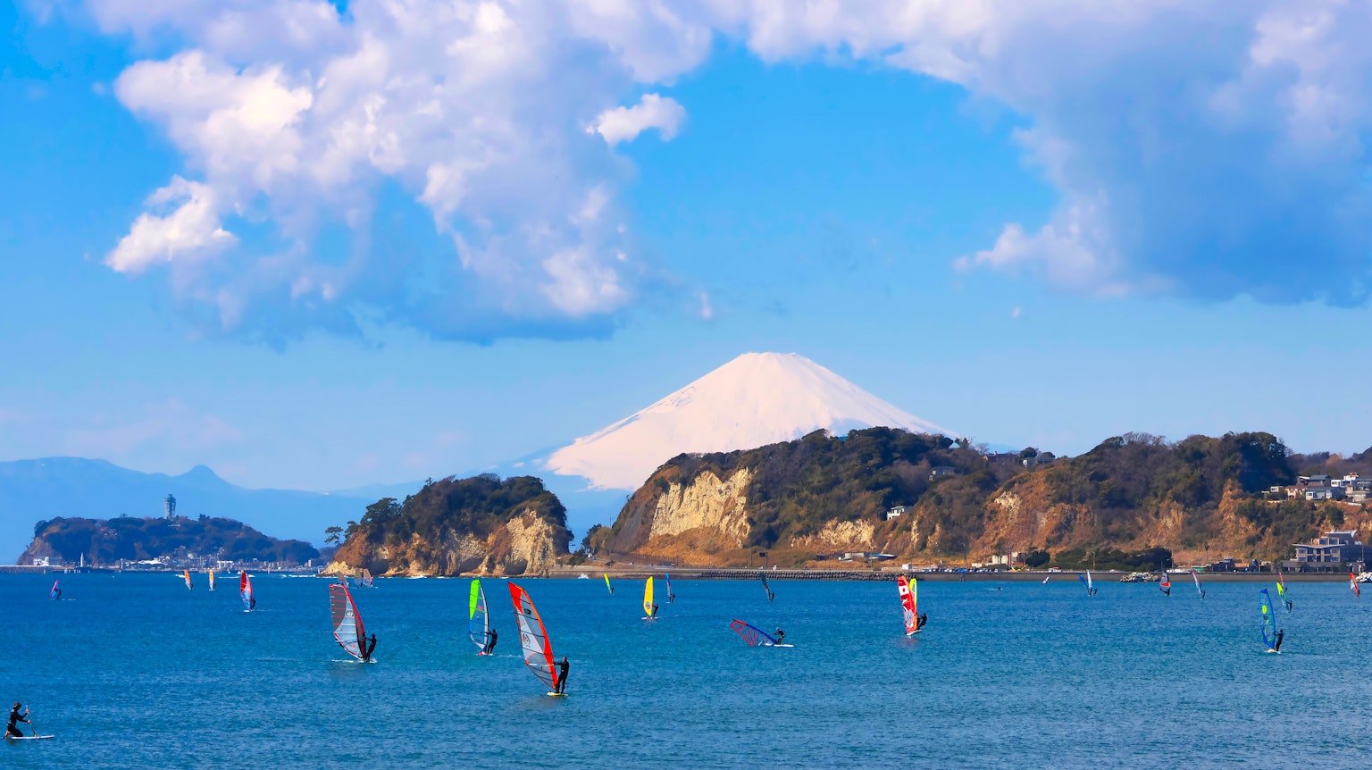 Escena de windsurf con el monte Fuji de fondo