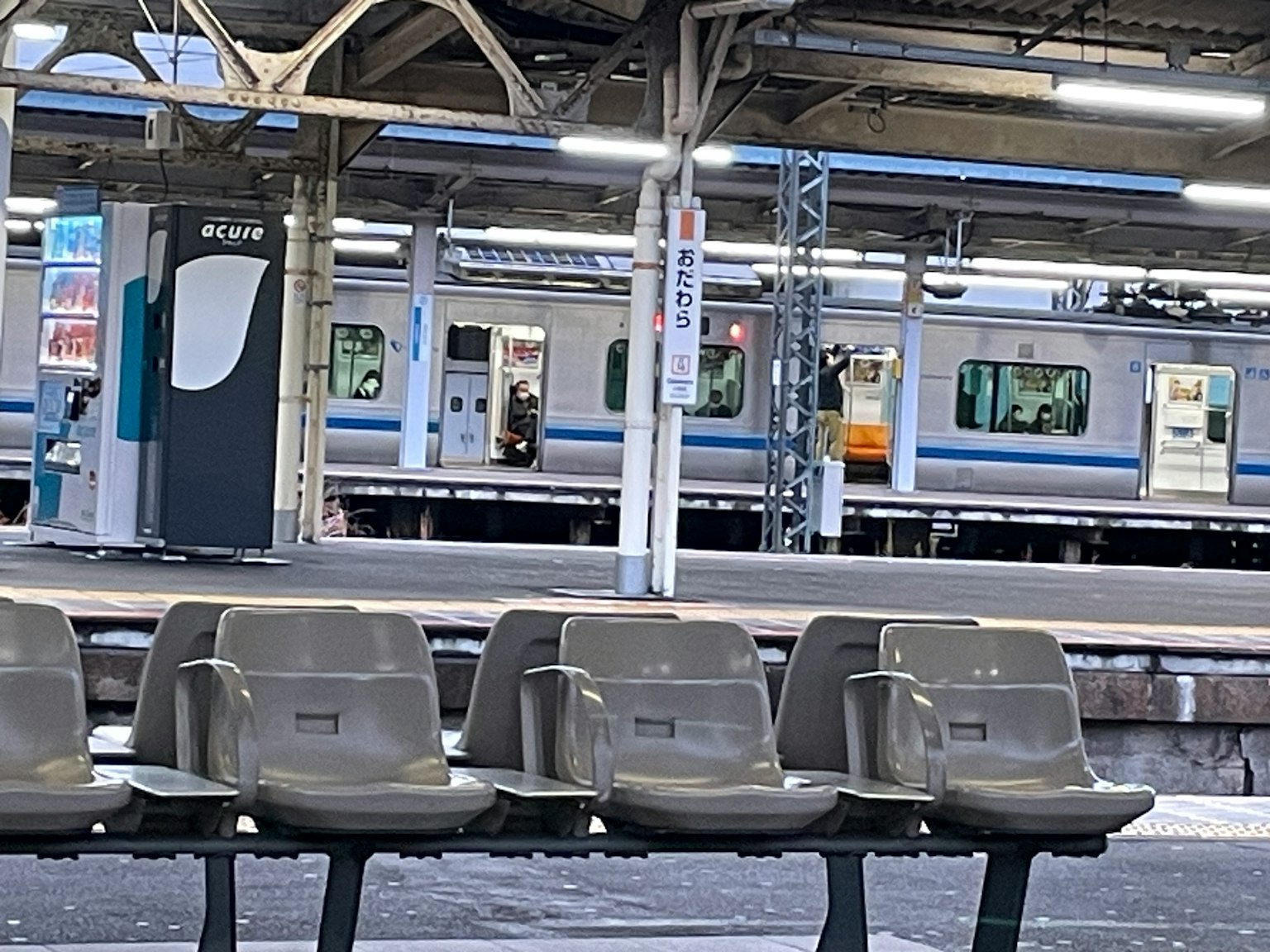 火車站候車區的灰色長椅和背景中的火車