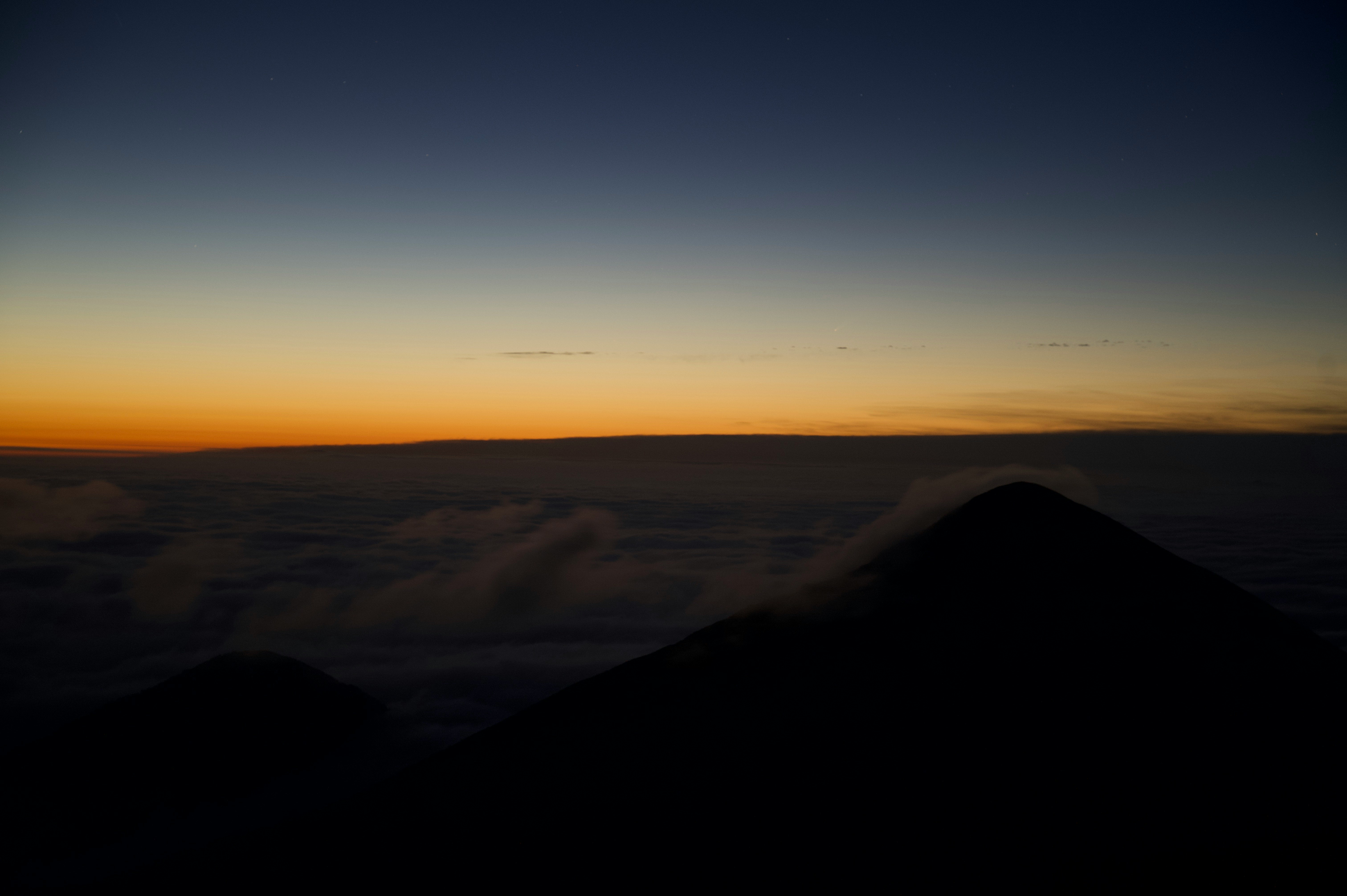 山の稜線から望む夕焼けの広大な地平線