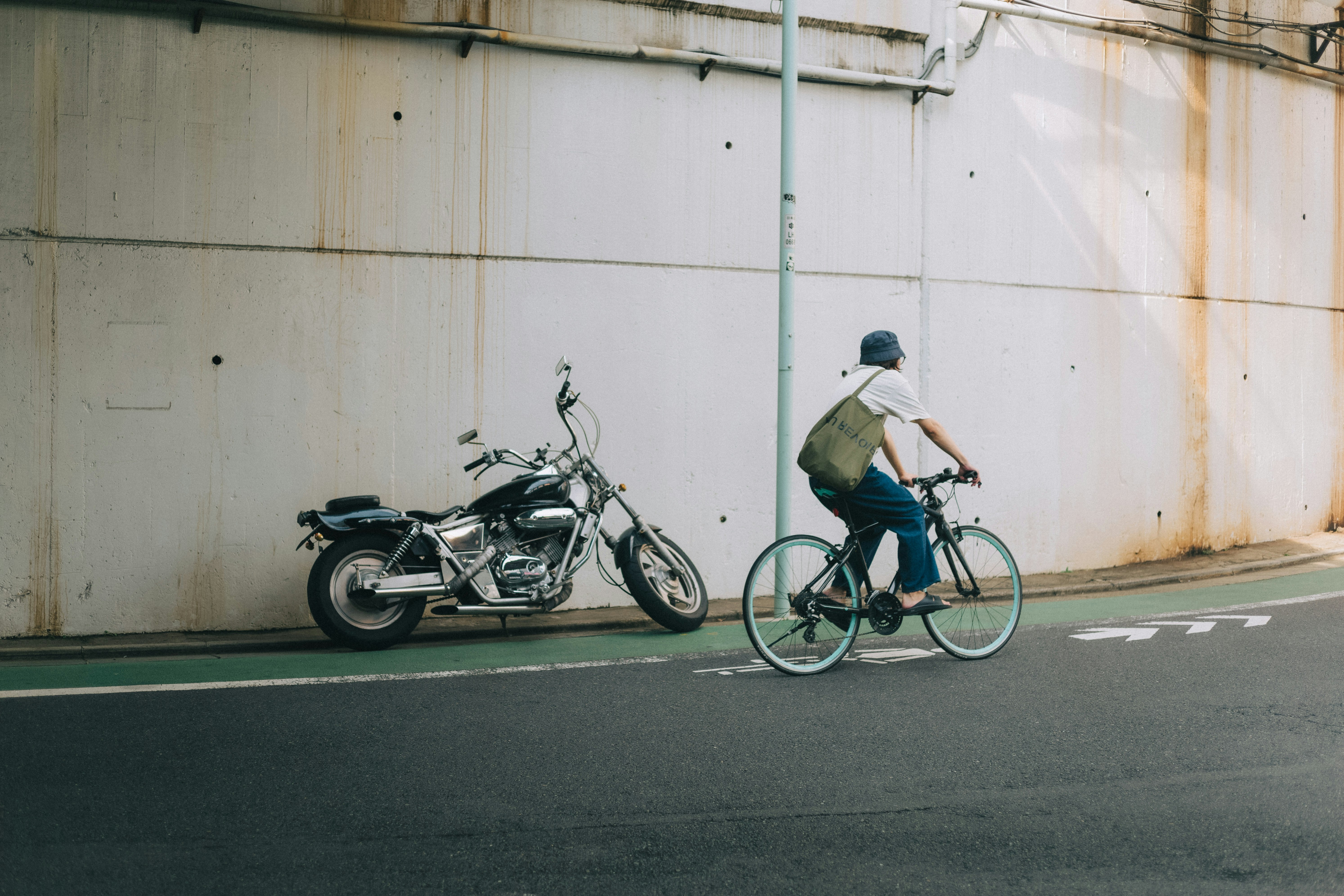 bicyclist riding along a lane beside parked motorcycles