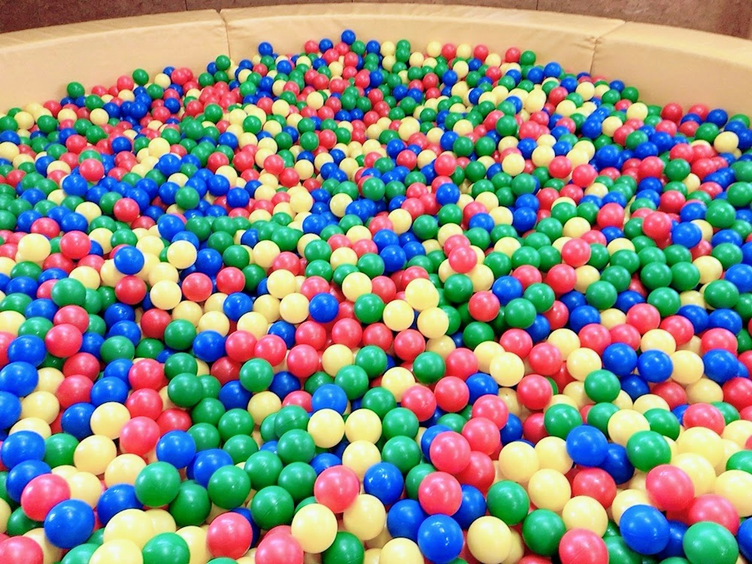 Une fosse à balles vibrante remplie de boules en plastique colorées de différentes couleurs