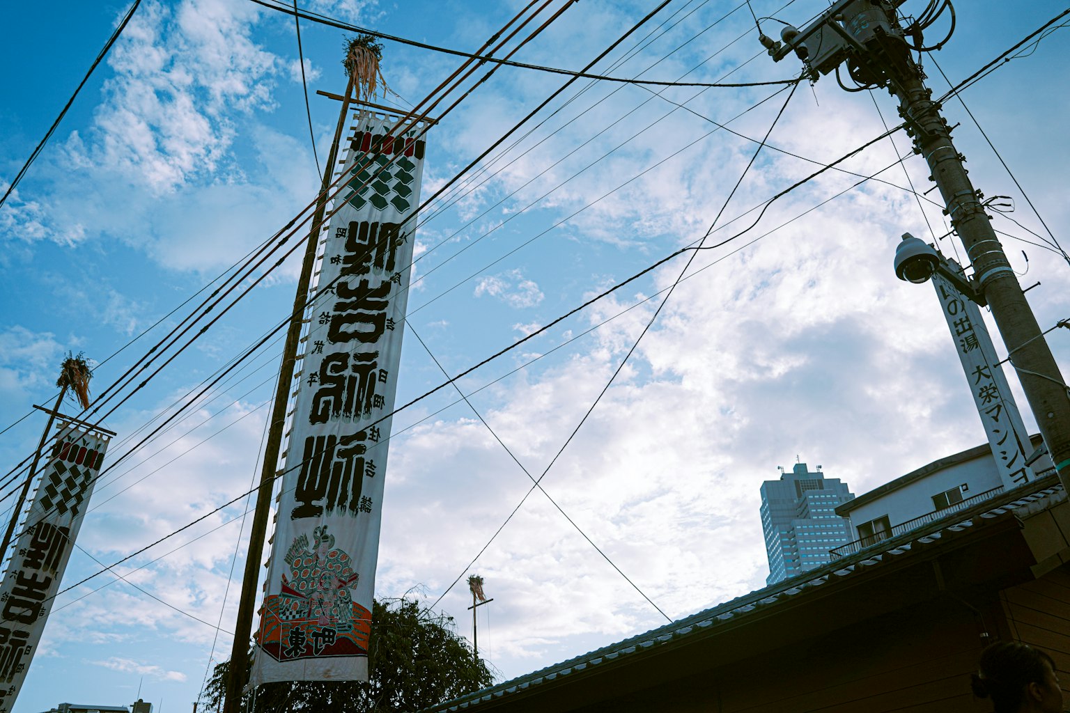 Una foto di grandi striscioni e edifici sotto un cielo blu con linee elettriche
