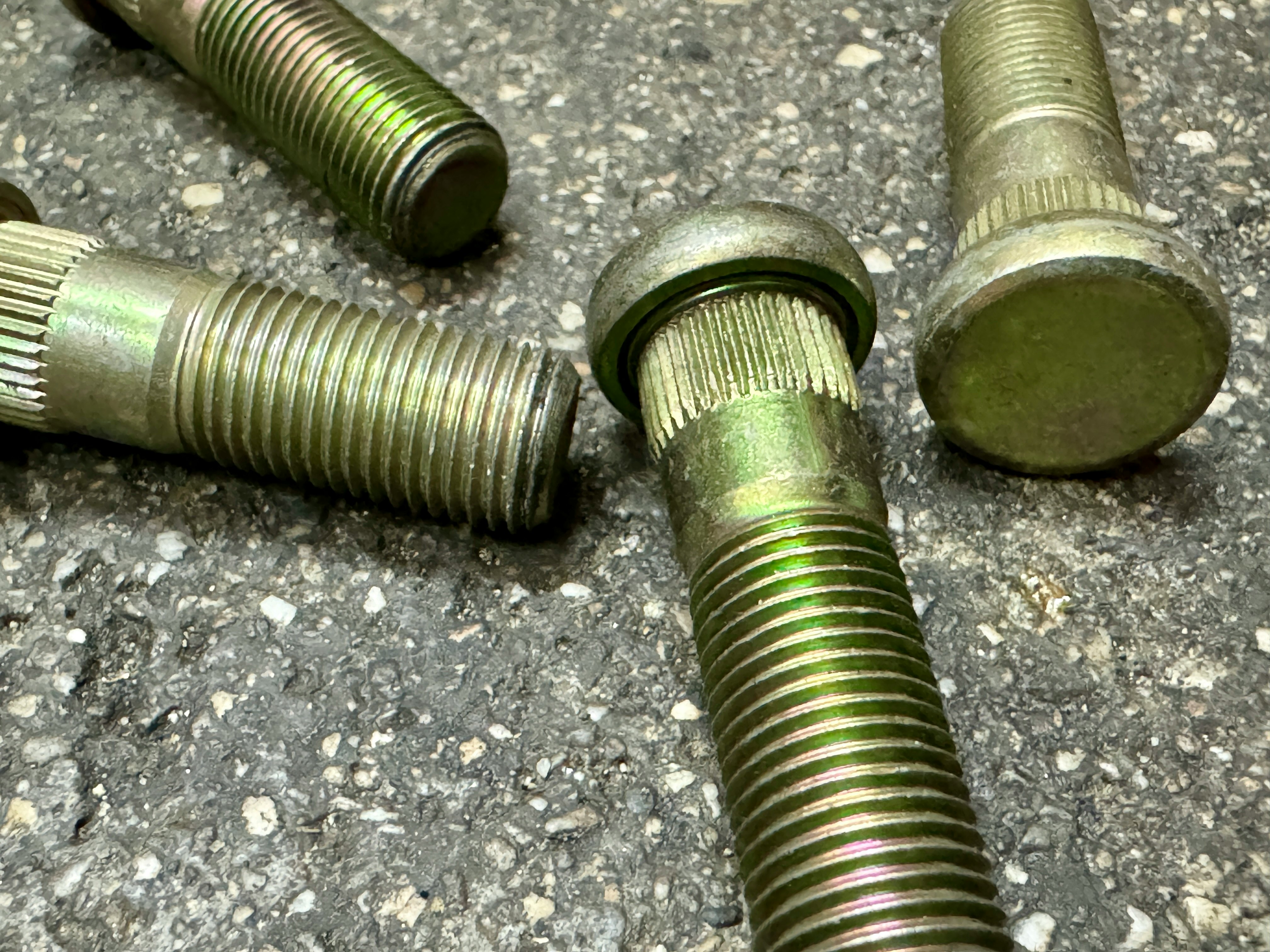 metal bolts and pipe fittings lying on a paved road