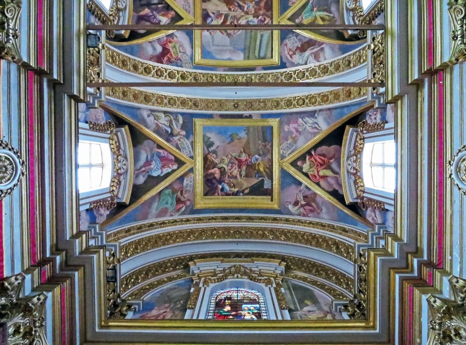 Magnifico soffitto affrescato con decorazioni dorate all'interno di una chiesa
