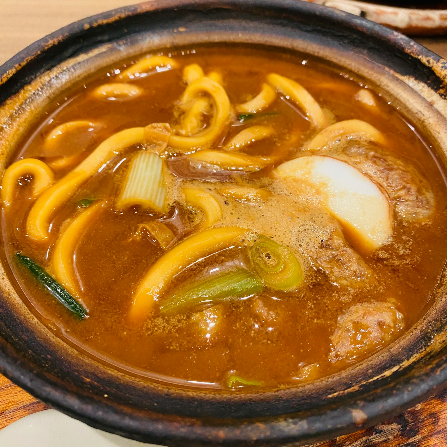 冒着热气的乌冬面碗，配有丰富的高汤和蔬菜