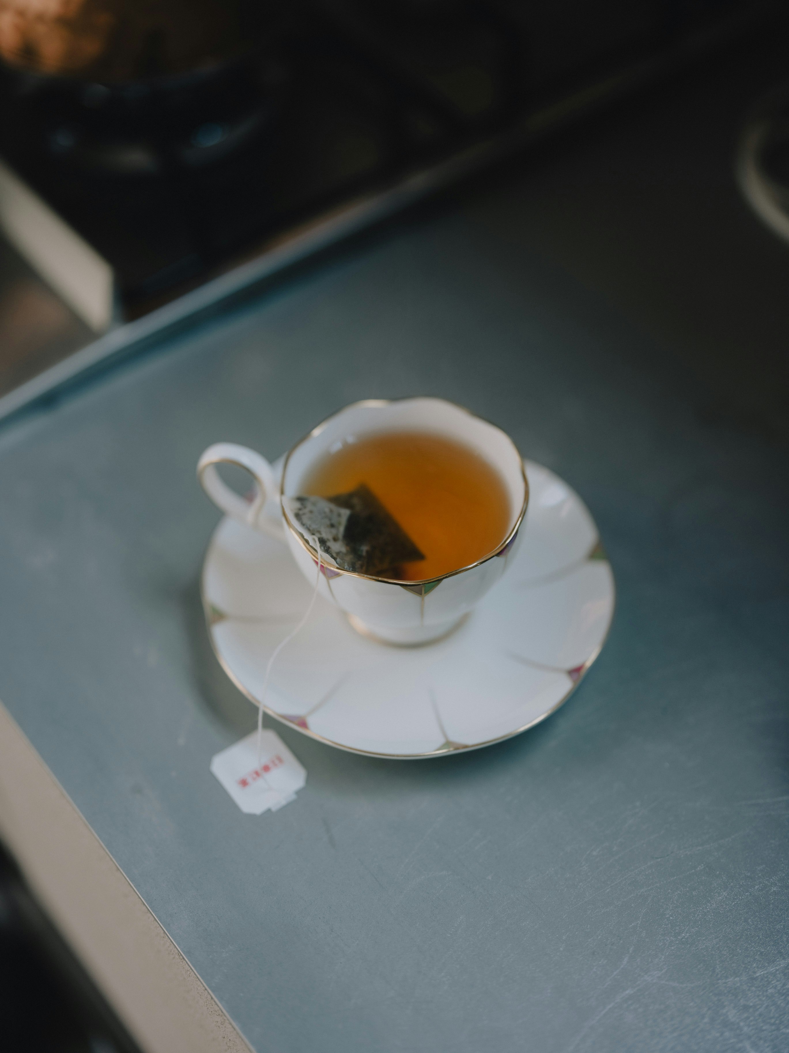 ティーカップに注がれたお茶とティーバッグのあるティータイムのテーブル