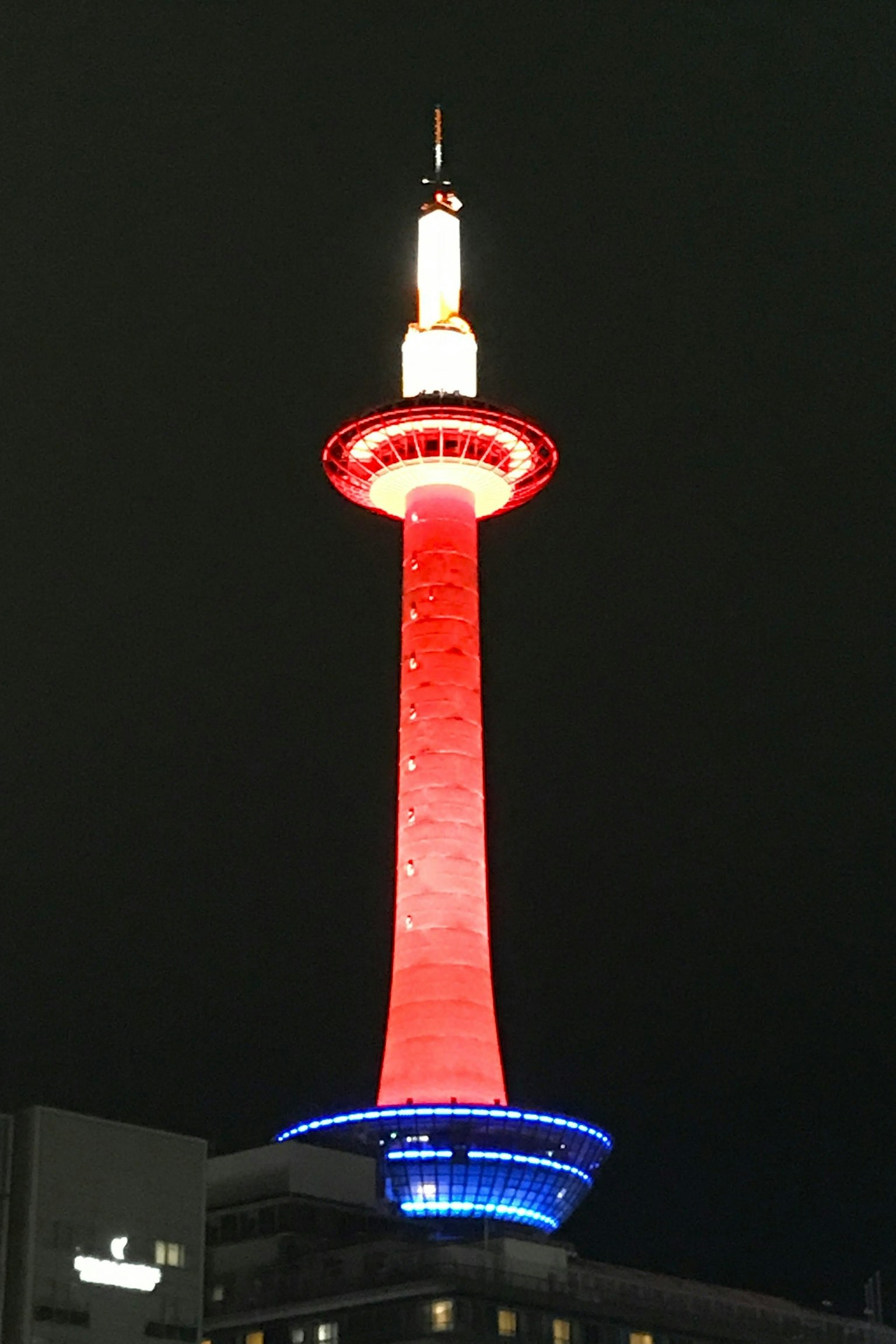 Menara Kyoto diterangi lampu merah dan biru di malam hari