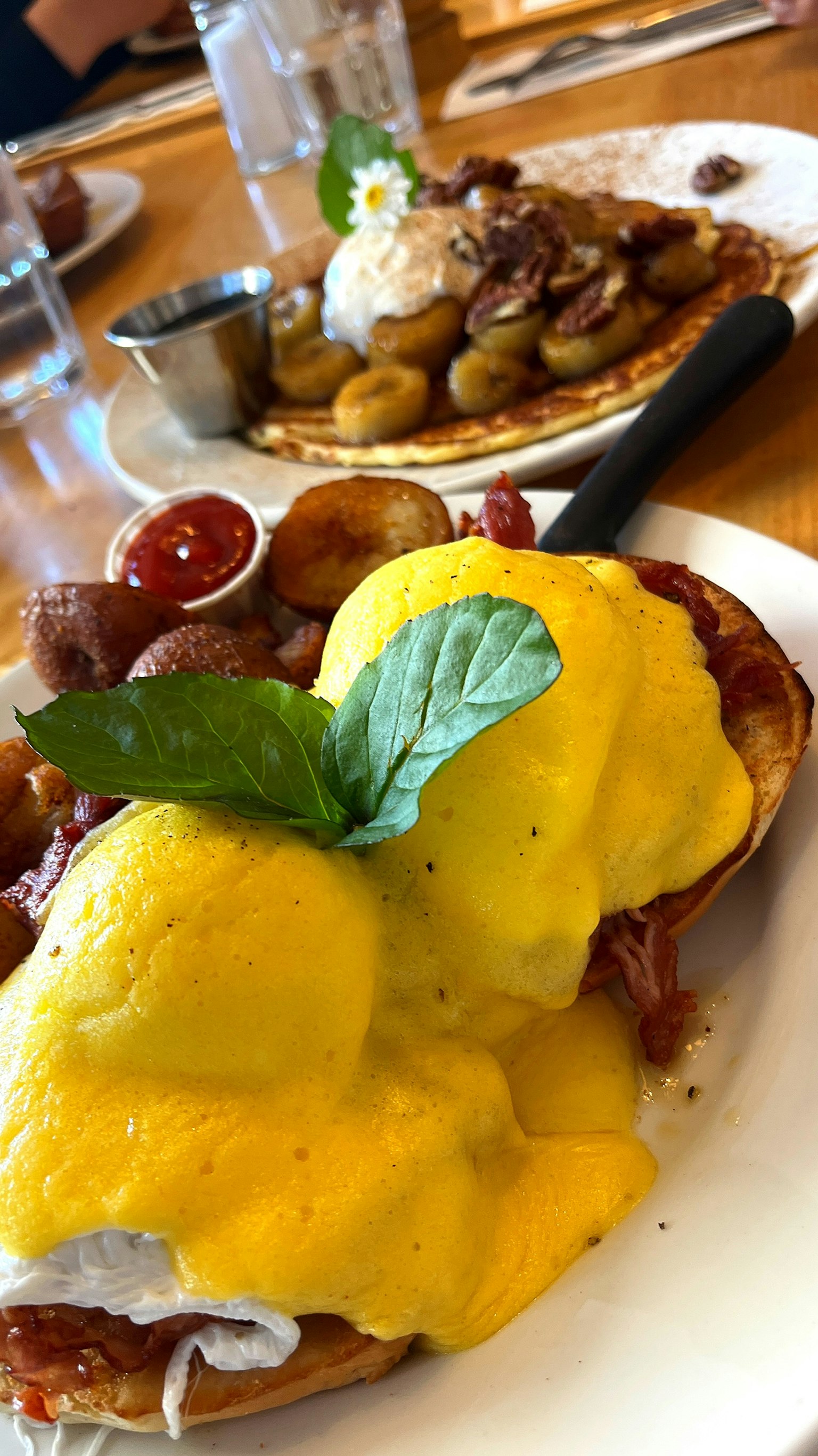 Oeufs Bénédicte avec du bacon et des pommes de terre sur une assiette