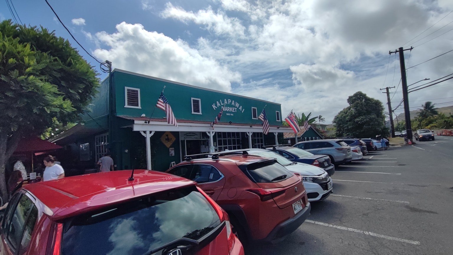 restaurant avec une façade bleue et des voitures garées dans un parking