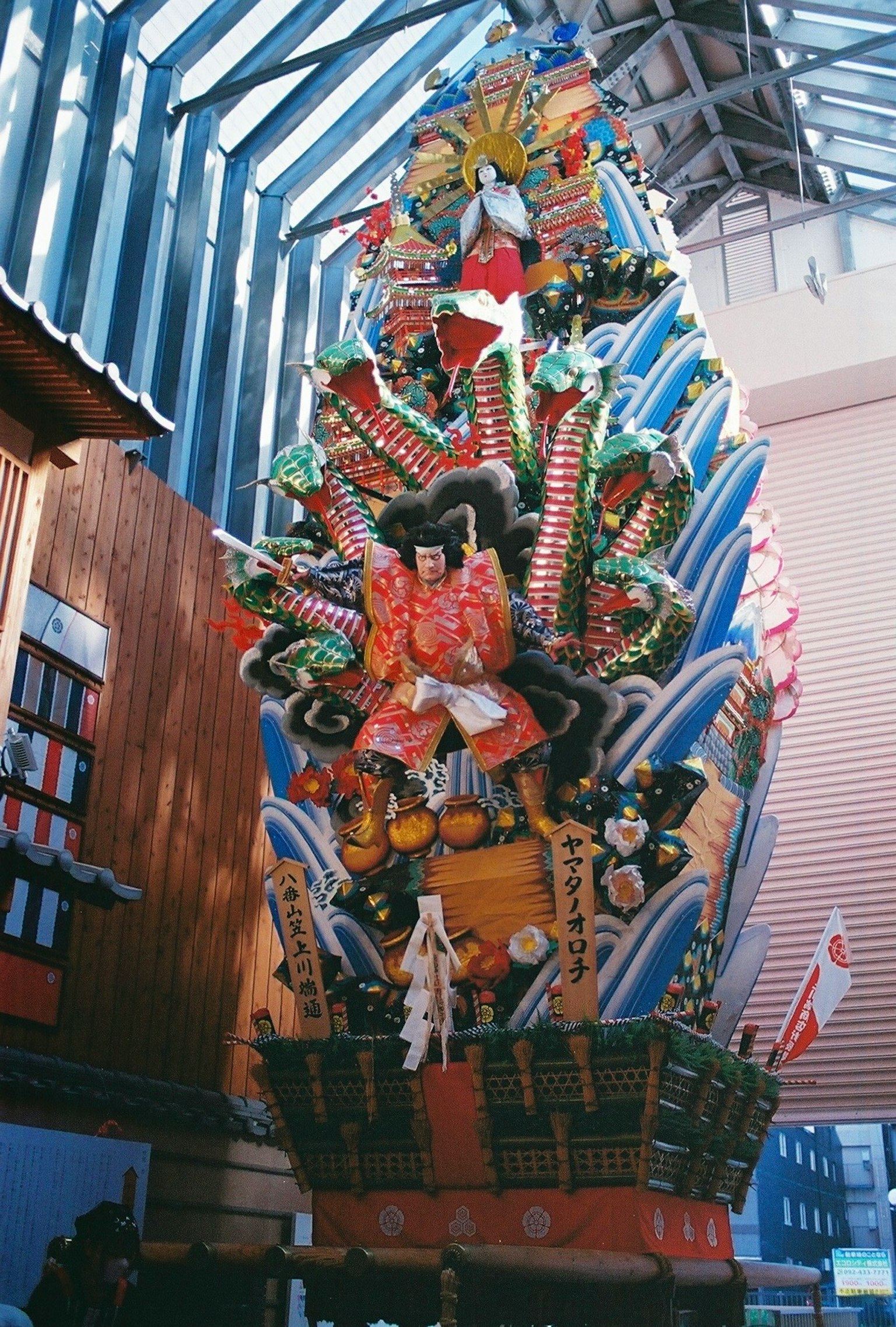 Large decorative ship structure with colorful ornaments displayed indoors