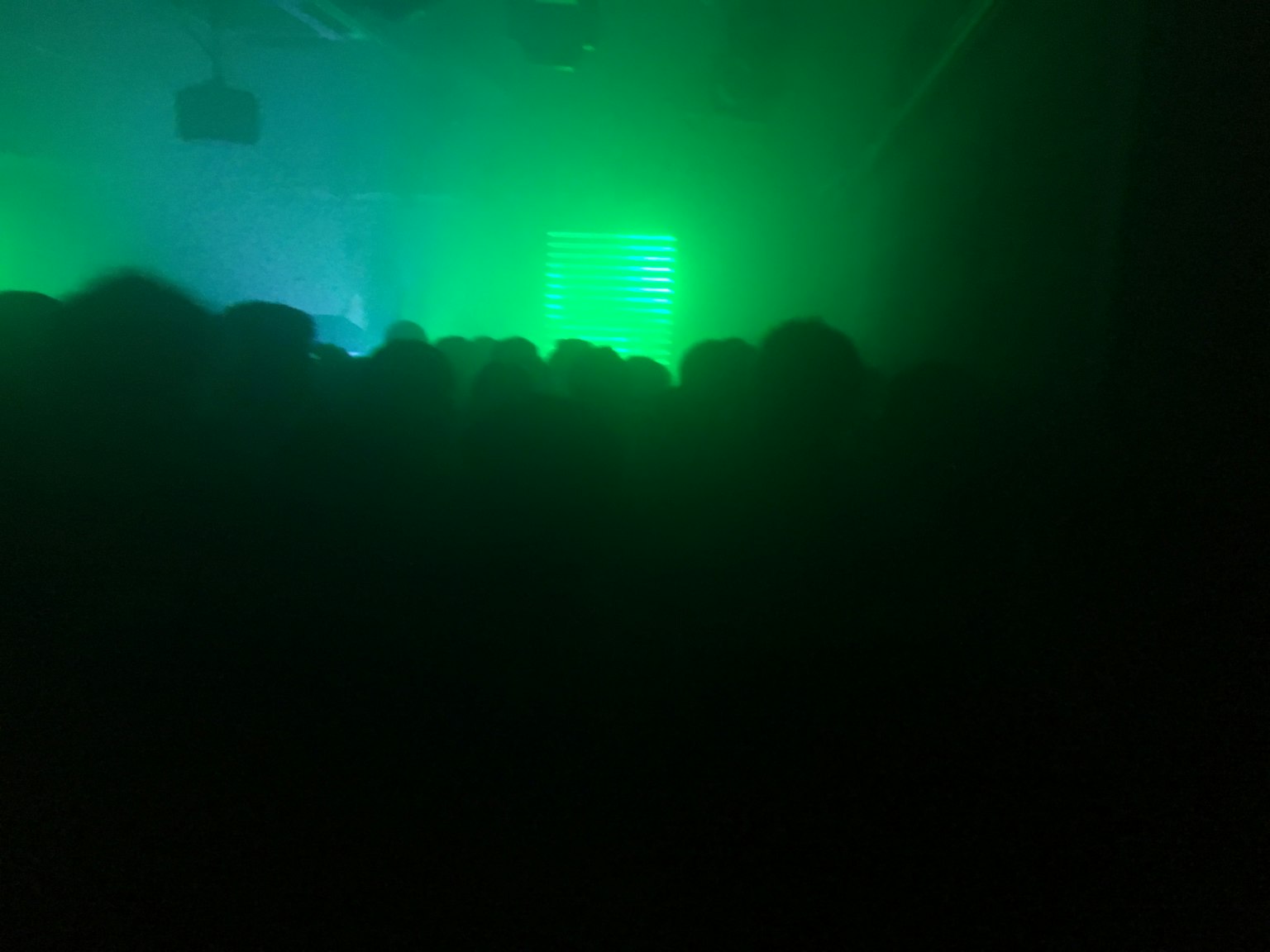 Scena di concerto con silhouette di persone in luce verde