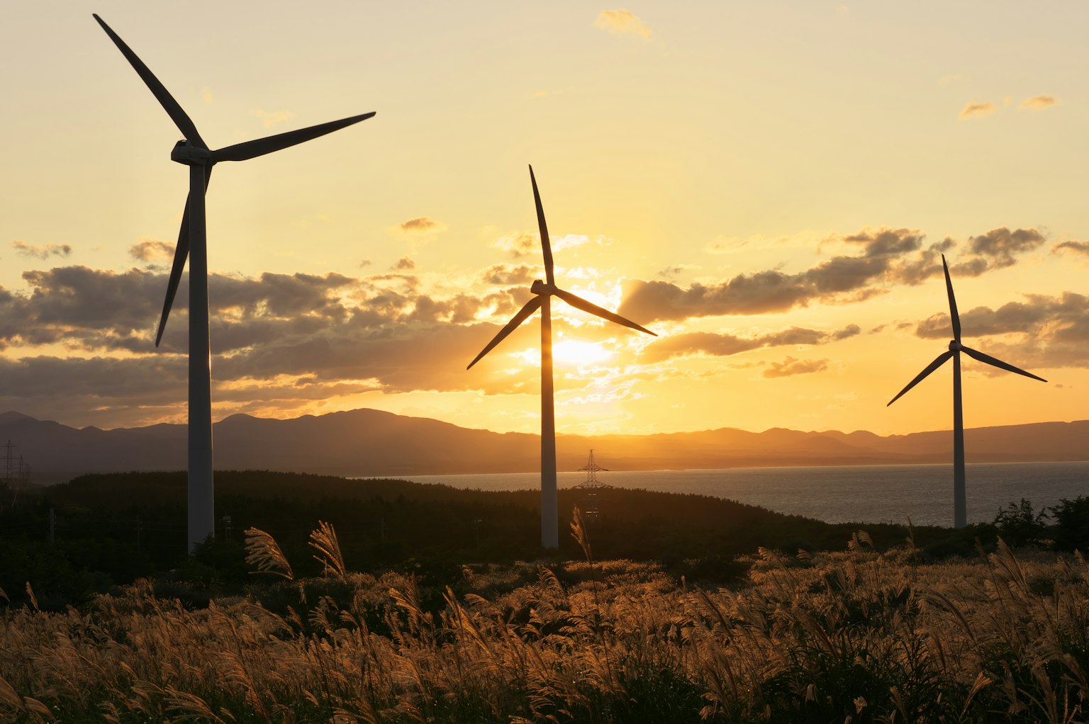 Wind turbines silhouetted against a sunset sky