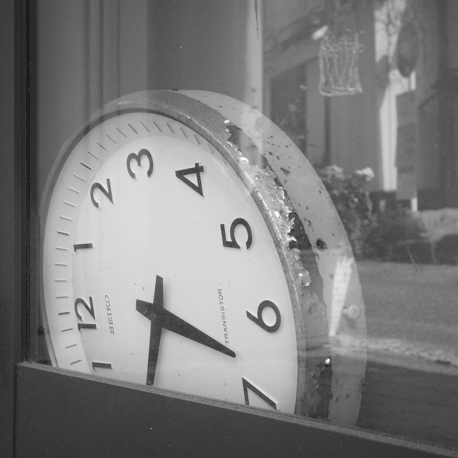 Orologio in bianco e nero visibile attraverso una finestra lancette che indicano le cinque
