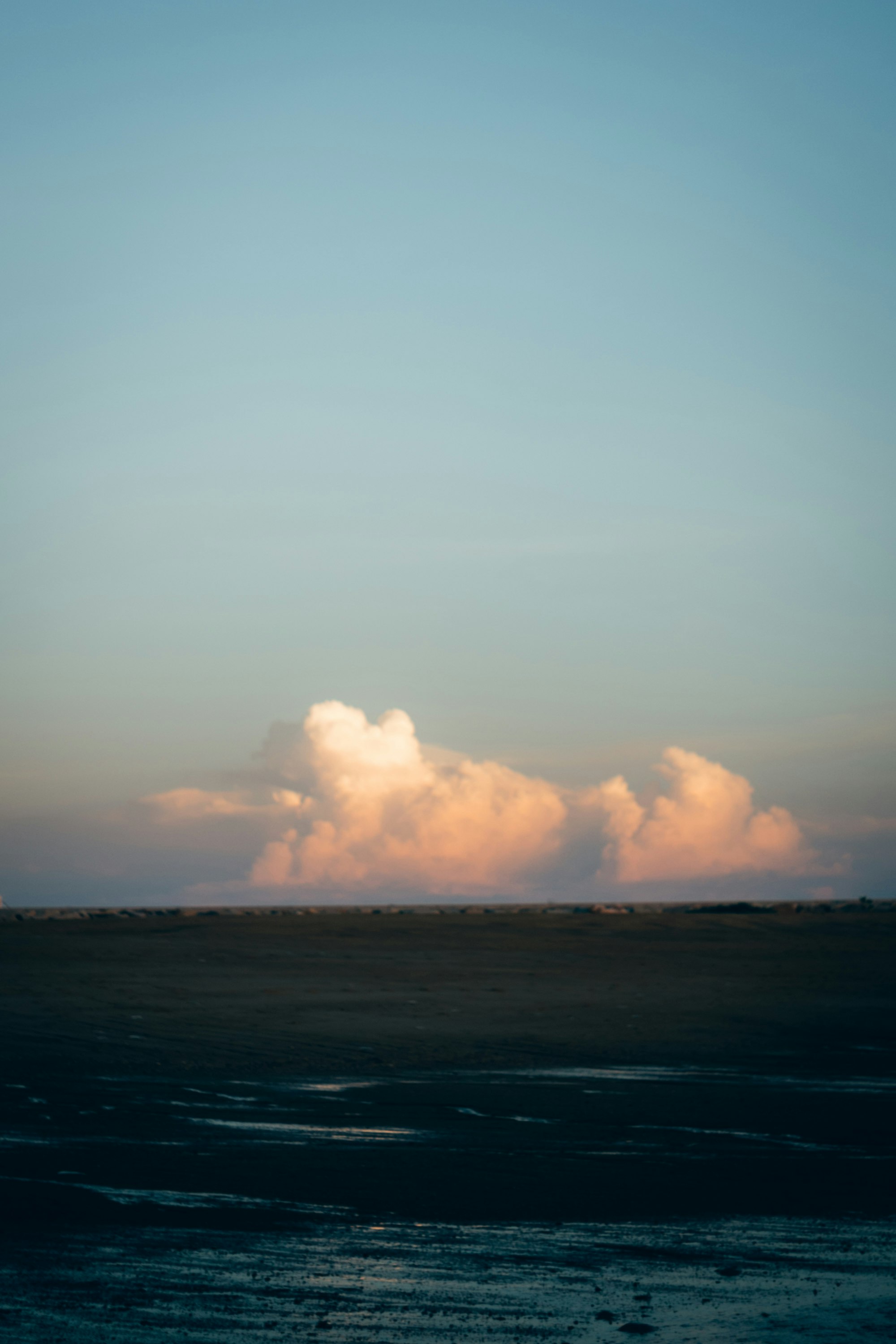 夕暮れの海辺に広がる水平線と雲