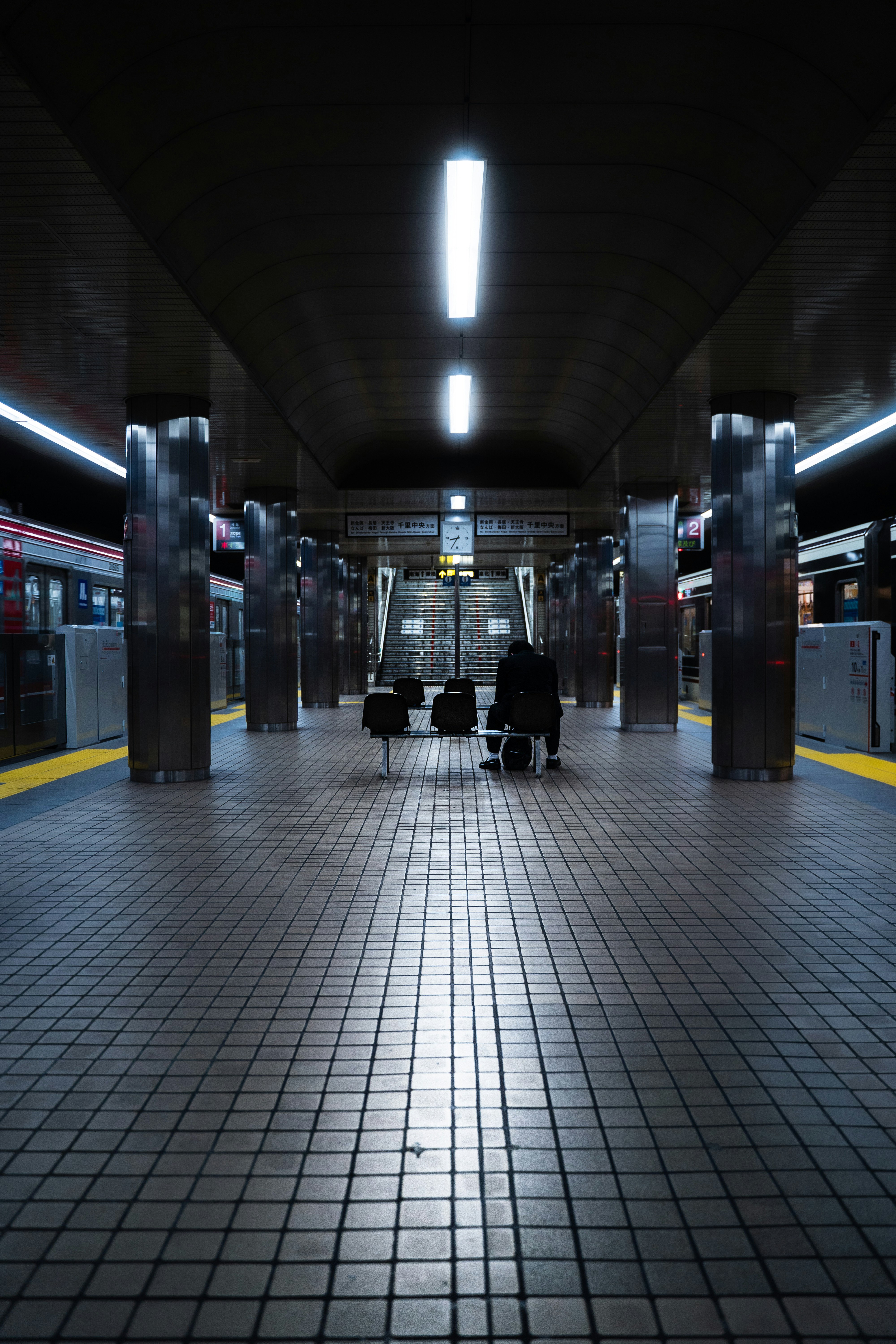 地下鉄のホームでベンチが並ぶ駅構内