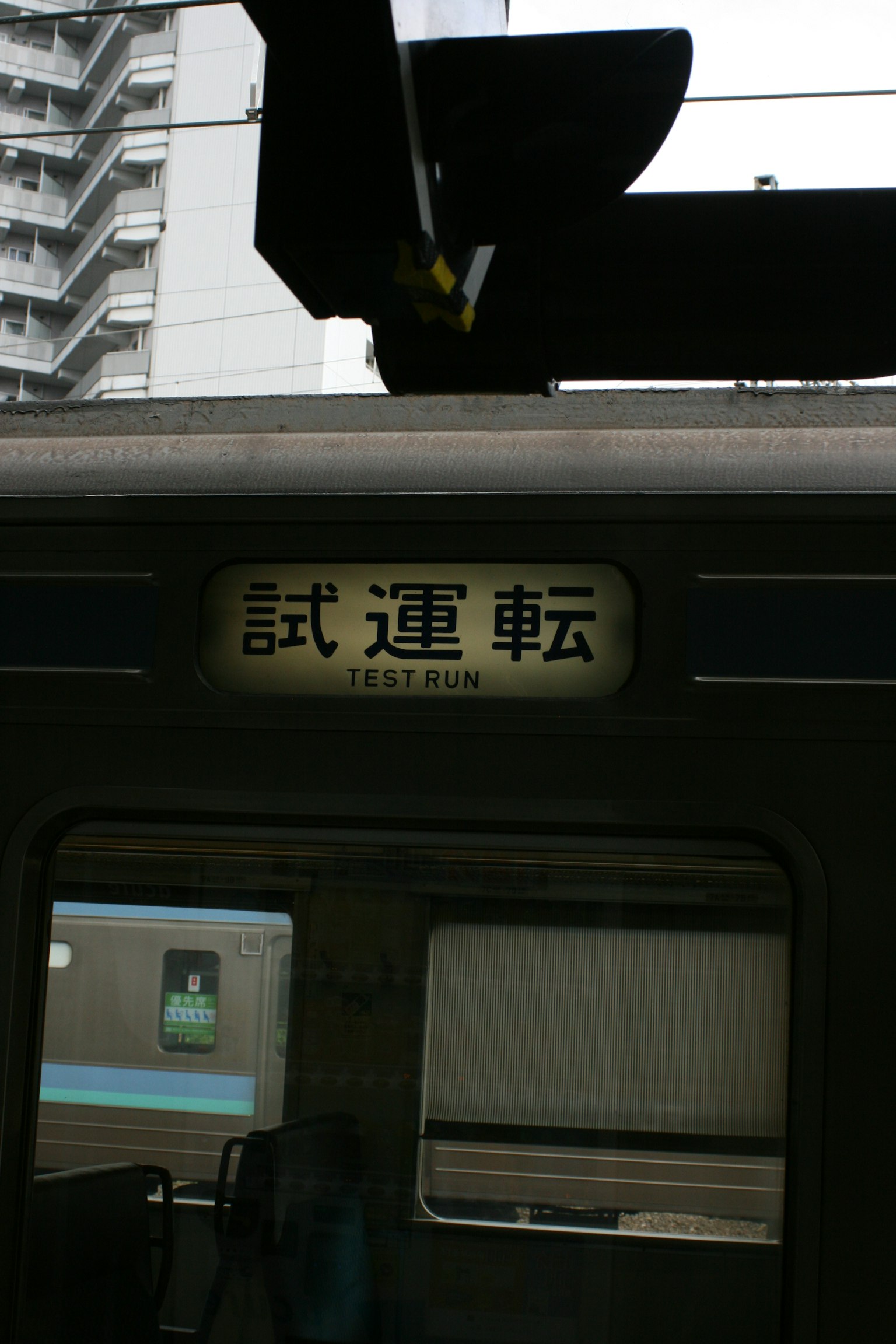A train labeled for trial operation is stopped at a station