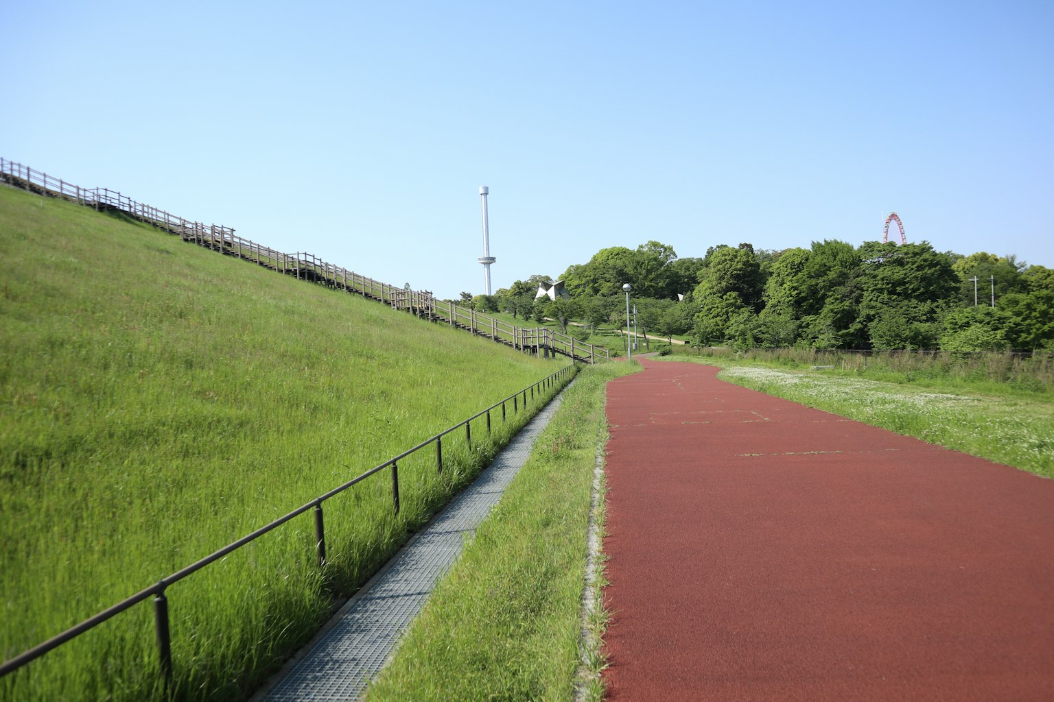 綠色草地和紅色跑道在藍天之下的風景