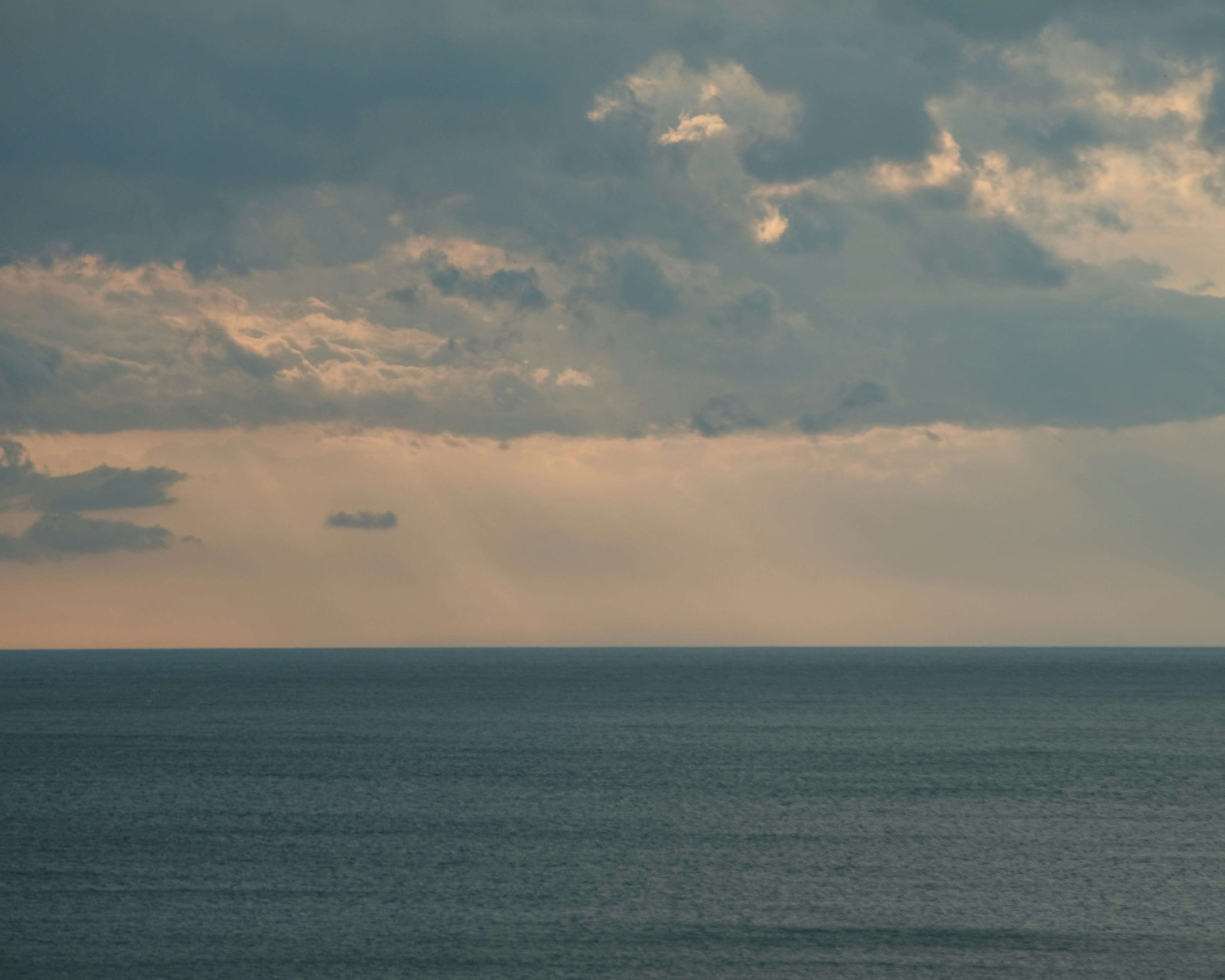 水平線まで広がる海と雲の空の夕景