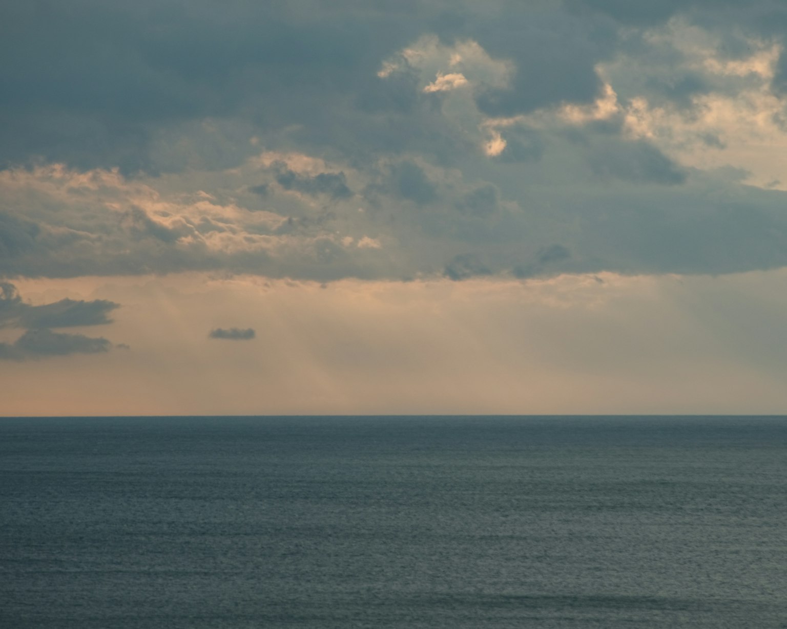 海景，云彩和柔和的光线透过