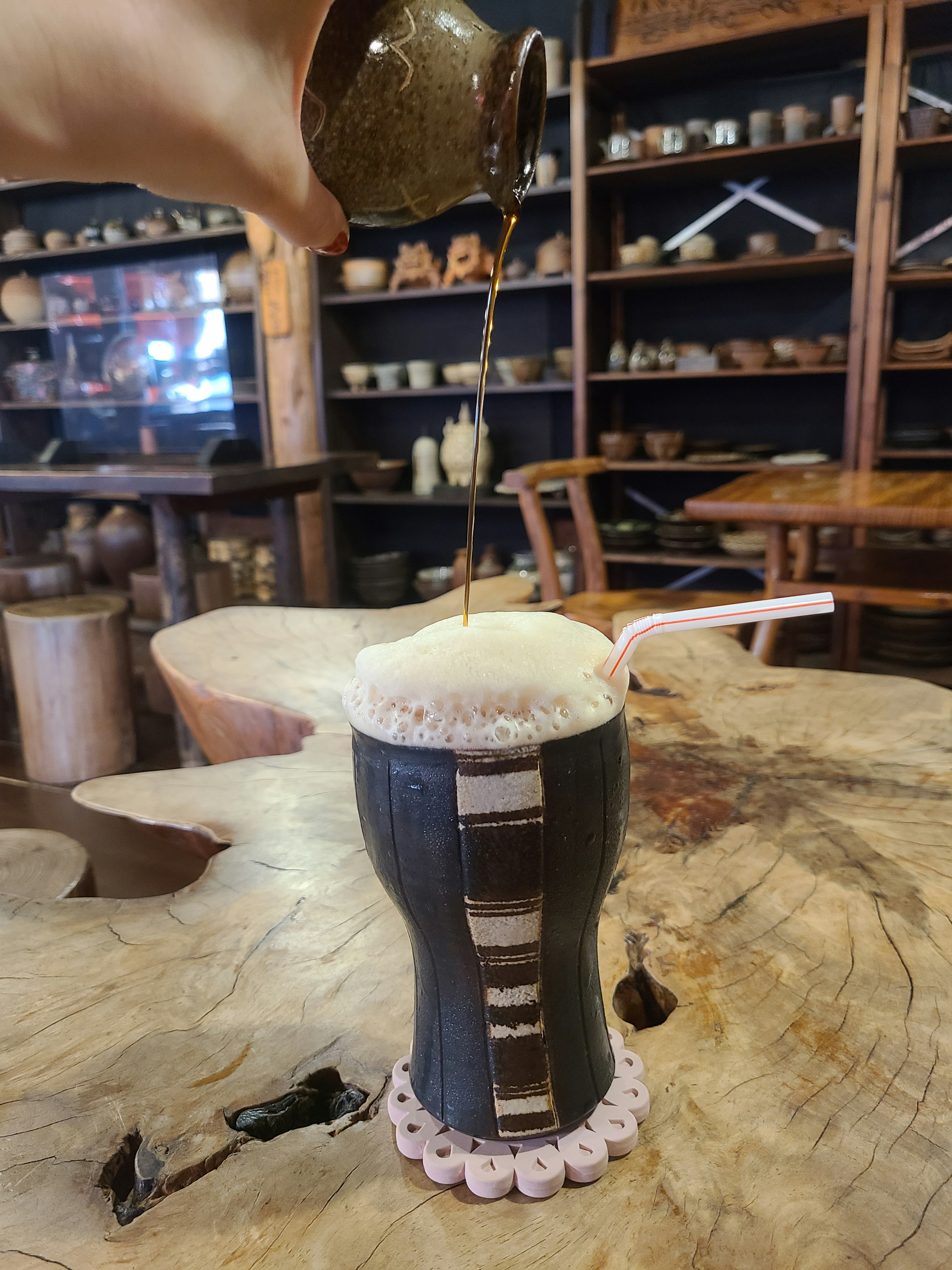 カフェのテーブルで注がれるビールと泡のグラス画像