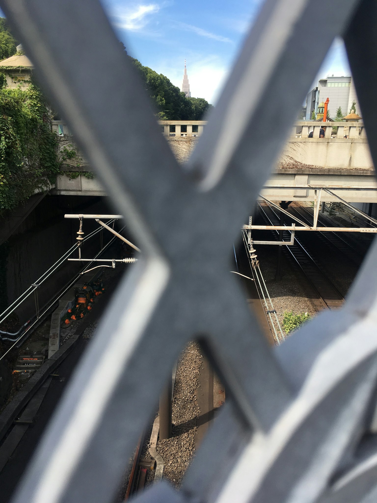 Vista de las vías del tren a través de una cerca de metal