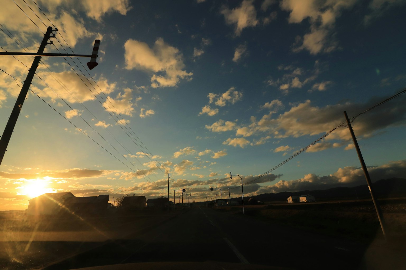 Sonnenuntergangslandschaft mit blauem Himmel und Wolken