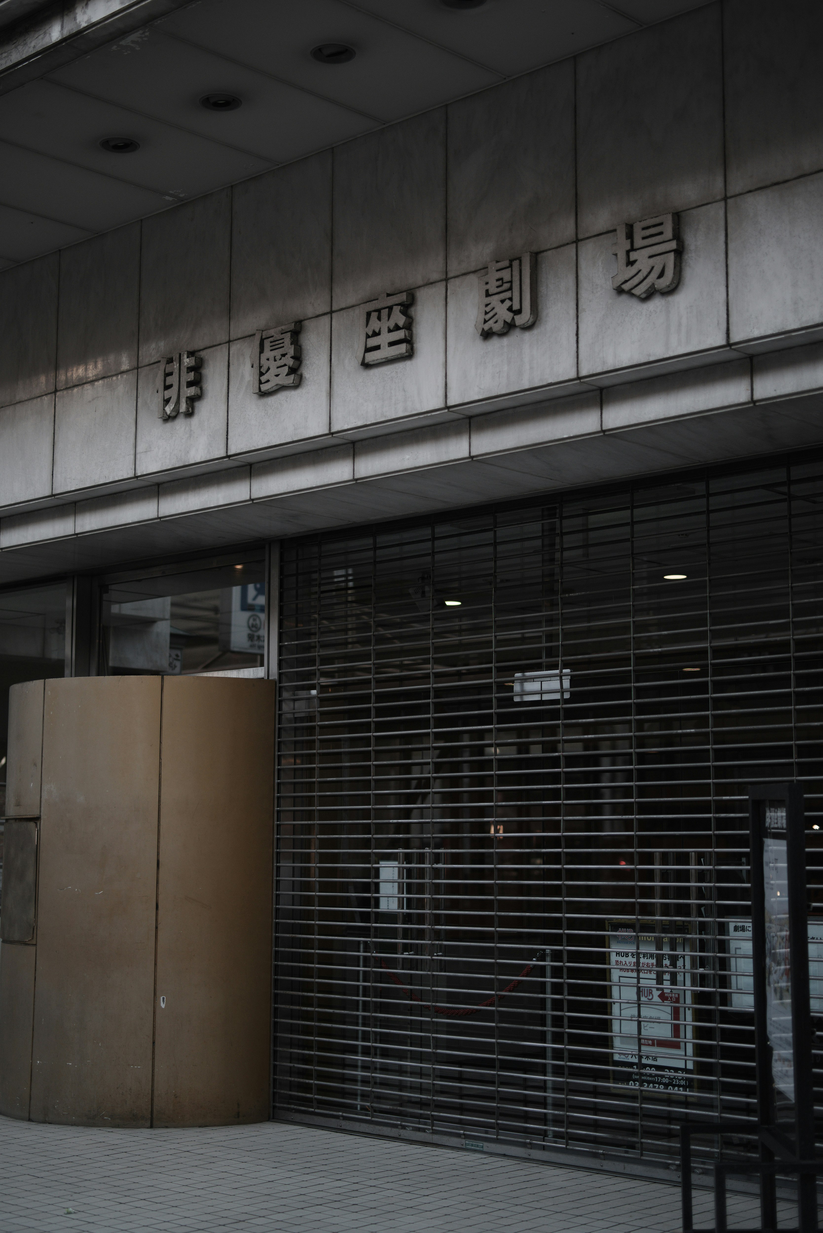 閉館告知のある劇場入口の看板と外壁