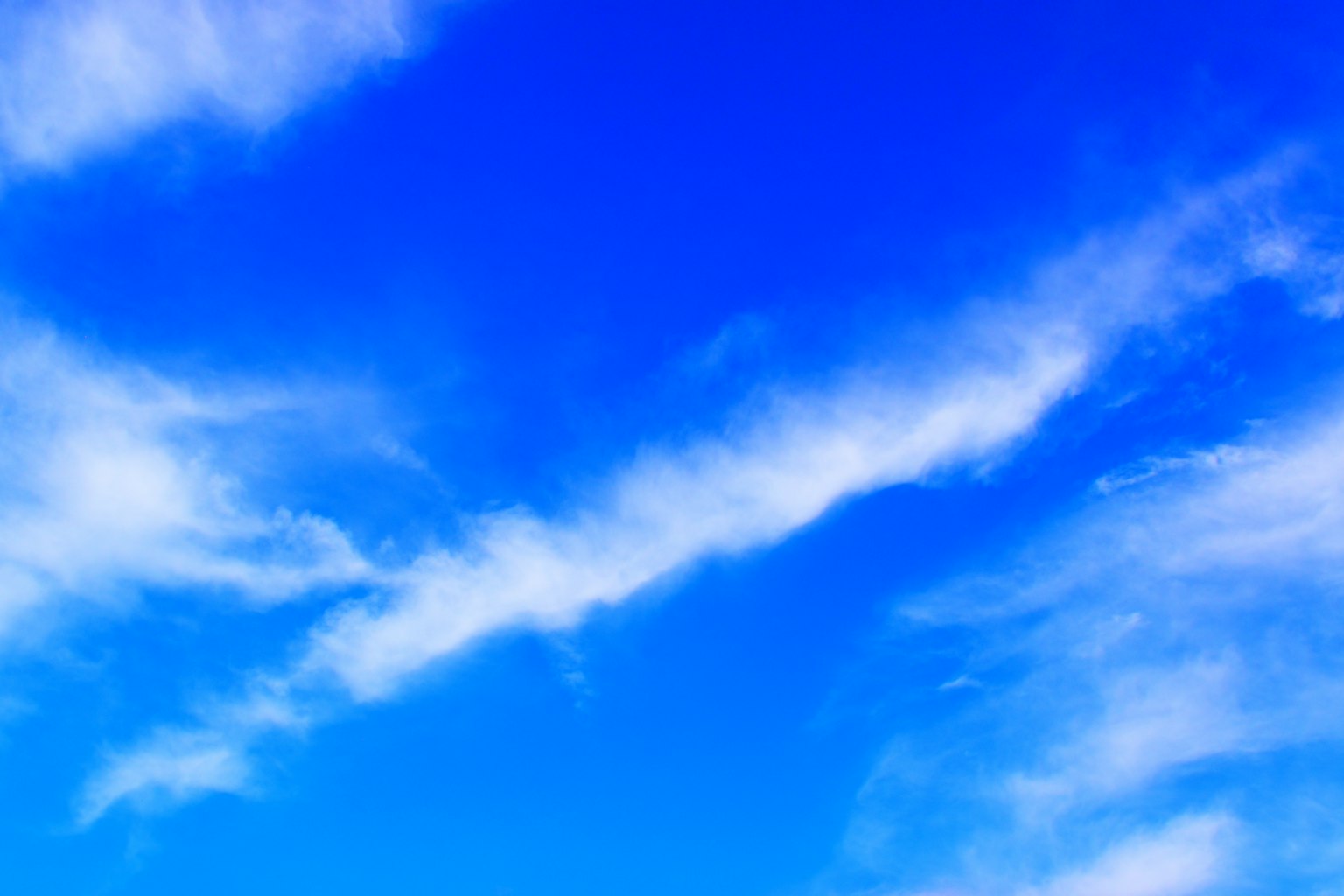 Lebhafter blauer Himmel mit wispy weißen Wolken