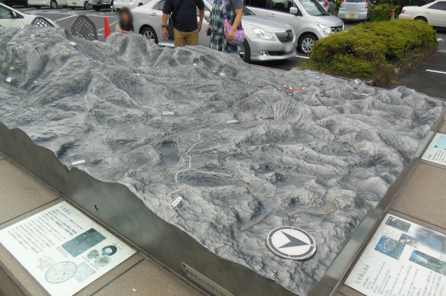 Modello topografico dettagliato esposto in un parcheggio con persone nei dintorni