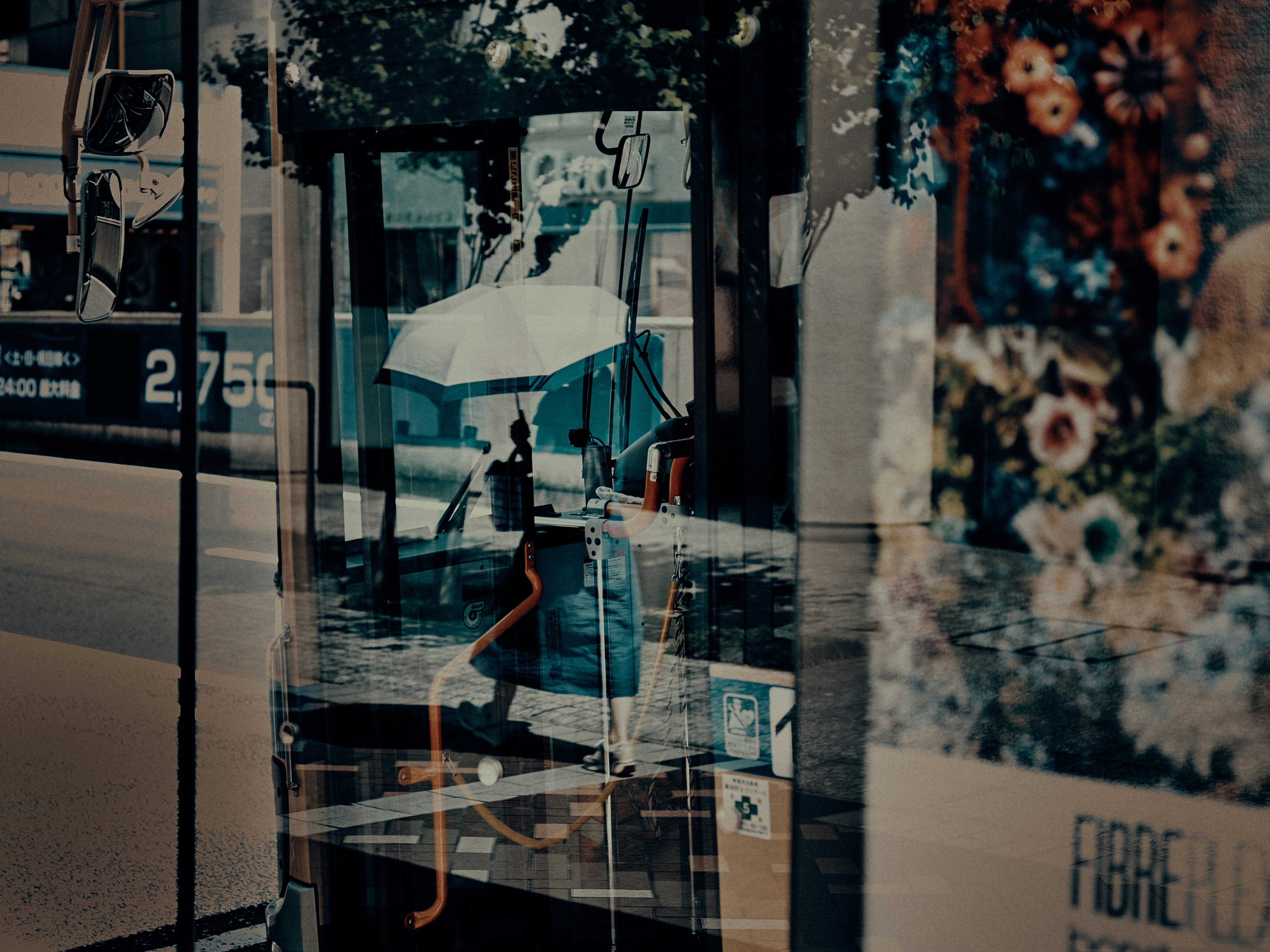 Reflection of a person walking with an umbrella in the rain in a city scene